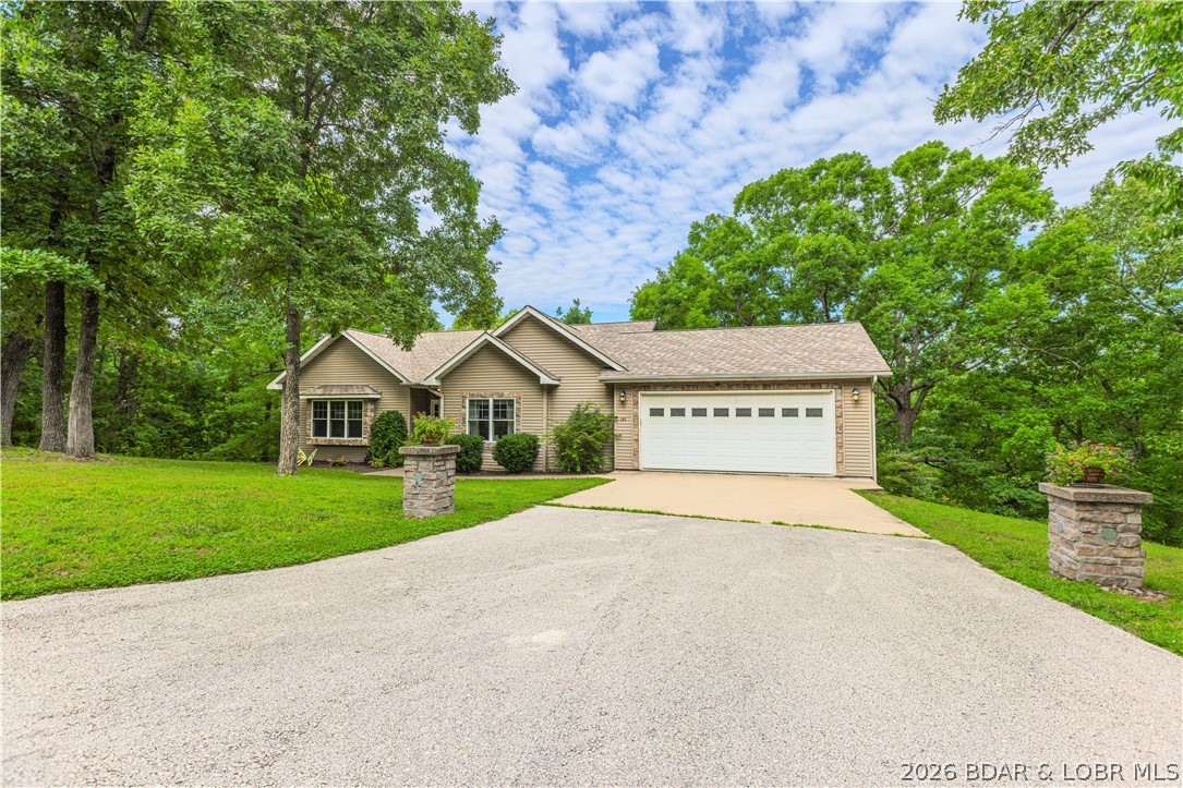 COUNTRY HOME that offers privacy on a dead end street, close to everything, on 1.5 acres.  This 5 bedroom/3 bath beauty offers a front yard for the pets or kids.  The back decks are perched in the trees where nature surrounds you with the perfect retreat.  3 bedrooms are on the main level with each of them offering architectural interest with vaulted ceilings (one with a loft/play space).  The master suite and 2 additional bedrooms are found on the main level with 2 more bedrooms and two separate living spaces downstairs.  The lower level could easily be a separated mother in laws quarters/apartment with plenty of room to add a kitchenette in addition to the large family room.  Two separate garages offer plenty of space for a man cave/workshop on the lower level and the perfect place to store your motorcycle.  This home has plenty of room to spread out with one of the most outstanding features being a country location with easy proximity to the school, the city center of Camdenton, and the hospital.  The location does not get any better than this one.  This would be a wonderful home for a large family, or a combined family with the lower level offering many options.
