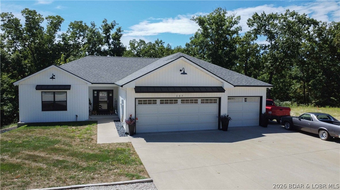Built in 2019 and freshly updated, this Oak Lane Estates home sits in a quiet Horseshoe Bend location minutes from the strip in Lake Ozark. Ideal for families, the main level features an open floor plan, a remodeled kitchen with quartz countertops and a farmhouse sink, and a natural gas fireplace. Fresh paint with shiplap accents, new stair carpet, and updated landscaping keep it move-in ready.

Smart home features include a monitored security system, a garage motion sensor, glass break window sensors, a connected furnace, and remote locking for the doors and garage.

The finished walkout lower level adds a bedroom, full bath, a second living area with an electric fireplace, and a utility room, ideal for guests. Step from the covered deck to the patio, with a fenced area great for a dog or kids. This fully drywalled 3-car garage includes a full size fridge, mini fridge and deep freezer. A full concrete driveway, with space on the side for two cars or an RV, plus a gravel spot out front for one more. A clean, insulated crawl space and basement storage add convenience, along with an owned water softener.

Sold fully furnished and turnkey. No HOA. School of the Osage district.