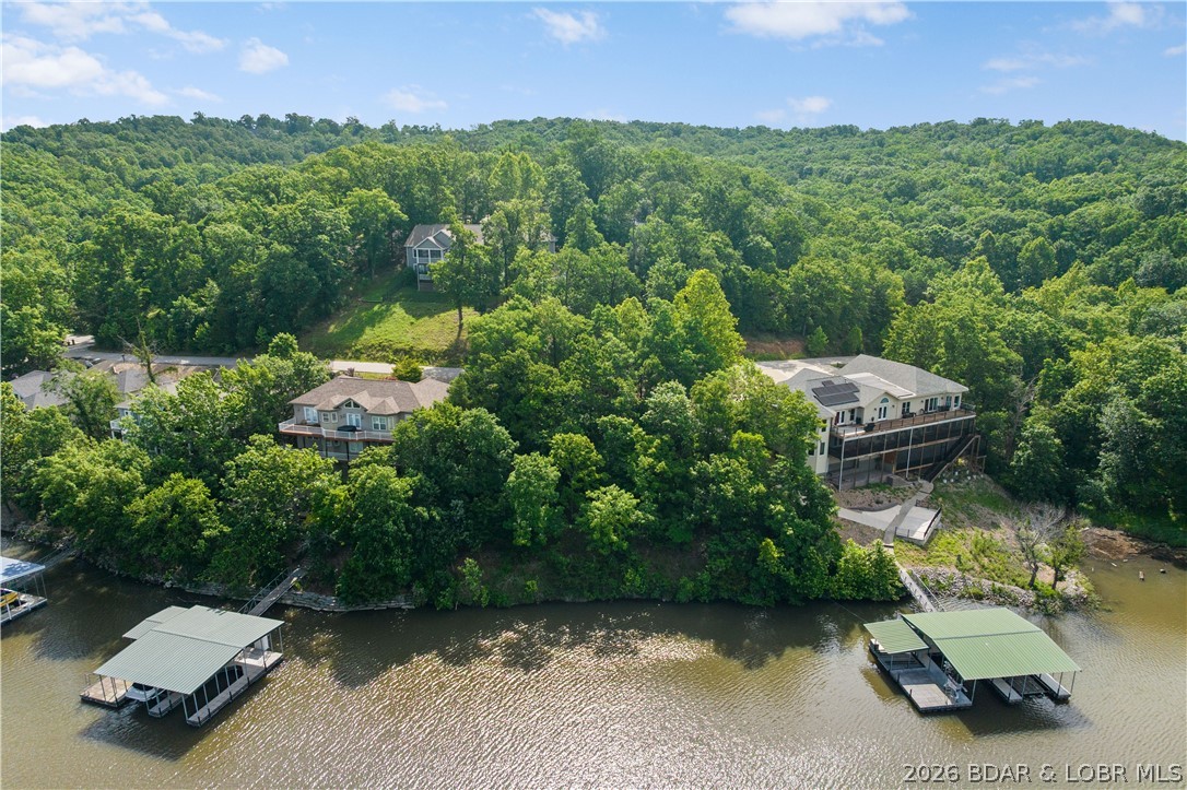 Discover this premier lakefront lot in the highly sought-after Cross Creek community, an exceptional park-like neighborhood just 4.2 miles off Hwy 54 on the outskirts of Camdenton. Nestled behind a secure gated entrance, this prime lot boasts 120 feet of pristine lakefront at the 31MM in Linn Creek Cove. Enjoy spectacular views and the ultimate peace of mind, framed beautifully by luxury homes already completed in the neighborhood. Cross Creek features top-tier amenities, including a zero-entry pool, playground, community docks with trailer parking, and brand-new asphalt roads winding entirely from the highway throughout the subdivision. Highly convenient to local schools, shopping, and only 15 minutes to Osage Beach; this location is ideal for a full-time residence or vacation getaway. Ready for your vision, the property offers hassle-free hookups to the community water and central sewer systems. Whether you are a builder or looking to construct your custom dream home, the seller is even willing to share their own architectural plans. Don't miss this rare opportunity for security, community excellence, and unparalleled lakefront living!