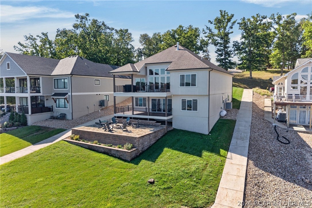 Newer construction with a three car garage is hard to find at the lake. So is a view like this one. The big open water sits to the northeast, which means afternoon shade on the dock, both lakeside decks, the grassy yard, and the fire pit. You can actually be outside during the hottest part of the day. A golf cart path runs down to the dock, and the subdivision has its own sand beach, which very few here can say.

The floor plan is the other reason this one stands out. Two bedrooms and two full baths on the main level, three more bedrooms on the walkout lower level, and two large living areas. Plenty of space for family and guests, and daily life still works on one floor.

The main level opens up with a big kitchen and living room plus a hidden walk-in pantry. High end finishes carry through the kitchen, the baths, and the details in every room. A wide concrete driveway adds parking for a crowd.

At the 1 mile marker of the Gravois Arm you are a short boat ride from lakefront restaurants and bars while staying in a quieter spot for a true retreat.