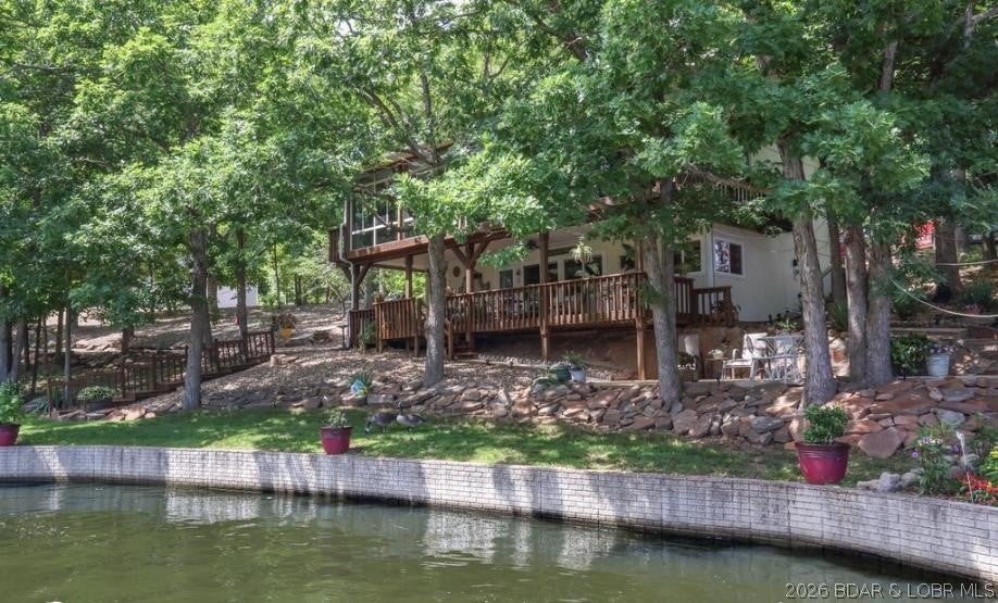 What a great spot to call your OWN PARADISE. AWESOME hard to find 40 x 50 shop building with a RV garage door and plenty of room for lots of play toys, large loft storage area to keep everything organized with a very nice lake home to go with it.  Great LAKE VIEW off the lower covered deck, or concrete patio for grilling or you might enjoy the upper lakeside Sunroom drinking coffee in cool winter mornings.  Lots of beautiful shade trees and nice landscaping with a almost maintenance free rocked yard with a large lakeside firepit.  The house is very spacious for year around living or just a weekend retreat in a private setting with lots of parking for family and friends.  Down stairs office or could be used for a 4th nonconforming bedroom..  Close to several fun spots on the lake including Patriots Point, Red Fox, Wet Spot, Boondocks is also not far away.  Seller will look at all offers, so bring them.