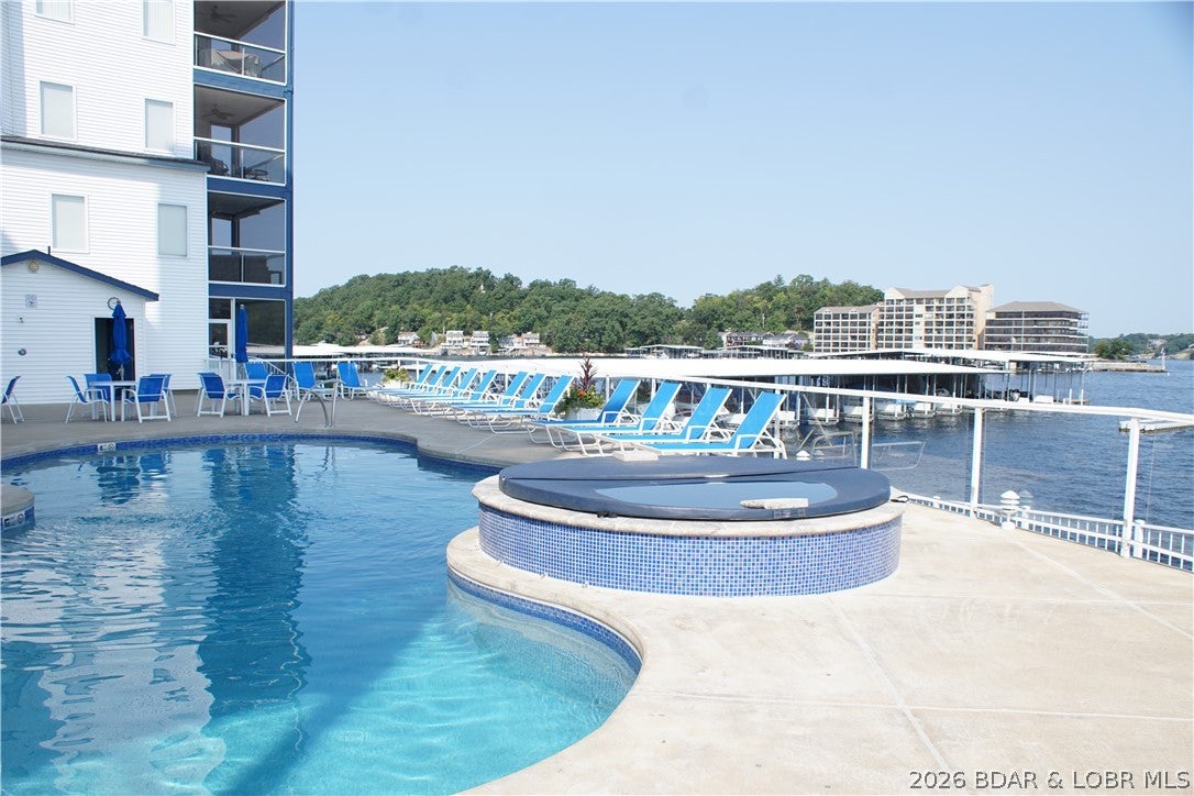 THIS BEAUTIFUL 850 sq foot ONE BEDROOM UNIT HAS A BONUS ROOM FOR EXTRA SLEEPING OR OFFICE. THIS UNIT IS PERFECT FOR THOSE FAMILY VACATIONS. DOCK 4R, SLIP#12, IS DIRECTLY IN FRONT OF THIS LOWER LEVEL WALKOUT UNIT. Special care   with all the new updating, makes the unit show like a display. From the New Stainless Steel appliance, New Walk-In Shower, ceramic tile, grab bars & Special made shower door, new LVP flooring throughout, ceramic tile in bathrooms, kitchen, and dining room. Most condos have a washer & dryer in a closet, this one has a Laundry Room with Newer washer & dryer as well as New ceramic tile & Water Softener. Window treatments & insulated draperies that shield the heat & cold for better heating & cooling bills. Enjoy the beautiful view of the Lake from the Screened-in porch or step out & stroll down the side walk with green grass & landscaping to the 3 Heated Saltwater pools with 2 hot tubs. HOA includes propane gas for the fireplace & outside grill, Water, Trash, Sewer, Dock Maintenance, Elevators to the pools, quarterly pest control, yearly dryer cleaning, pet area, Spectrum hi speed Internet with TV channels. Great Location, beautiful Sunsets, very popular area.