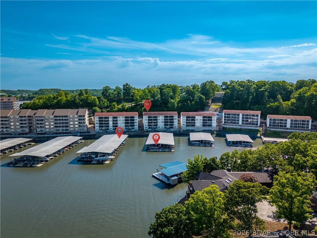 Rare opportunity at Lighthouse Landing!  This fully furnished 4-bedroom, 3-bath condo offers the perfect setup for large families, entertaining, or hosting extended guests with 2 master suites, 2 separate living rooms, and 2 private decks. The upper screened deck is the perfect place to relax after a day on the lake, while the lower-level deck walks directly out to the dock, making loading the boat and heading out on the water incredibly convenient.  Included is a 12x32 boat slip in Dock 5 located directly in front of the condo, allowing for easy views of your boat right from the unit, plus a PWC slip with hoist for even more fun on the water. Located in a quiet cove, Lighthouse Landing is ideal for swimming, fishing, kayaking, and paddle boarding with calmer water. The complex also features a heated community pool and large designated pet areas, making it perfect for full-time living, vacation use, or investment potential. By both land and water, you are only minutes from all the entertainment, restaurants, shopping, and attractions of the Bagnell Dam Strip. If you have been waiting for a large condo with incredible functionality and easy dock access this is the one to see!