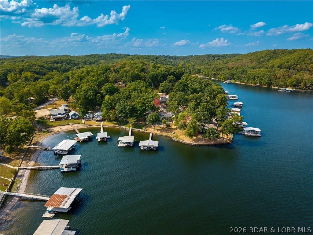 LOCATION, LOCATION, LOCATION! Enjoy lakefront living and spectacular main-channel views from this spacious 4-bedroom, 2-bath home with a 2-car detached garage and private dock featuring 2 slips. Full of character and well cared for, this home offers a wonderful opportunity to enjoy it as-is while adding your own personal touches over time. With two fireplaces and beautiful lake views from numerous windows throughout, the setting is hard to beat.

The main level features a kitchen and dining area, living room, 2 bedrooms, and a full bath. The lower level provides even more living space with an additional bar/kitchen area, family room with fireplace, 2 bedrooms, full bath, laundry/utility room, and a convenient lake storage room.

Step outside from the walkout lower level to the patio and take in the incredible views overlooking the main channel of the Lake of the Ozarks. With a private dock, generous living space, garage, and a fantastic lakefront setting, this home is ready and waiting for you to make unforgettable memories with family and friends for years to come. Bring your vision, add your personal style, and make this special lakefront property your own!