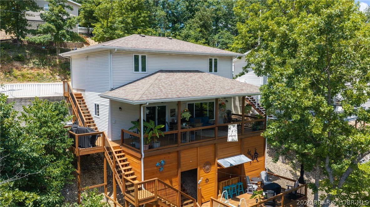 The kind of lakefront property buyers wait for—deep water, protected cove, updated throughout, and ready to enjoy from day one! This stunning remodeled 3 bed/3 bath home is tucked away in a no-wake deep-water cove off the Osage 32MM, offering the perfect combination of protection and quick access to the main channel. Features an updated kitchen with newer appliances (2024), refreshed cabinetry (2025) & pantry, while the fully remodeled primary bath (2024) boasts a tile walk-in shower, dual vanities and modern finishes. All but 1 window replaced and a large lakeside picture window added (in 2025) fills the living room with natural light and complemented by a stone gas fireplace. Two bedrooms overlook the lake and the oversized covered deck plus lower entertainment deck with custom bar are perfect for relaxing. Detached 2-car garage (2016) includes an insulated guest room. Private 2-well dock offers 11x30' & 10x30' slips with 6,800 & 8,000 lb hoists, 20' water, depth, slide, wet-step ladder, kayak, paddle boat and storage locker. Same cove as Bulldogs and just 1 mile from Captain Ron's!