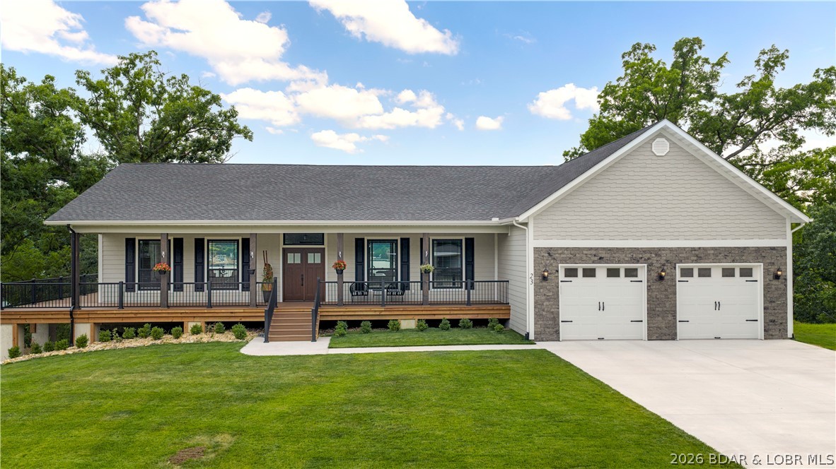 LAKE OF THE OZARKS - Breathtaking, panoramic lake vistas meet pure luxury in this brand-new construction masterpiece. The 2,100 SF open main level shines with soaring tongue-and-groove vaulted ceilings, hardwood floors, a stone fireplace, and endless water views from the 3-side wrap-around covered and open deck. A chef's kitchen boasts white shaker cabinets, black granite countertops, and a massive gas range. Relax in the primary ensuite featuring a walk-in closet and custom tiled walk-in shower. A spacious laundry room offers ample cabinets and tile flooring. Outside, a large plush green yard showcases premium manufactured stone veneer accents, Diamond Kote shake siding, LP ExpertFinish lap siding, a flat driveway, and an oversized 2-car garage. Inside Lake Ozark city limits minutes from Bagnell Dam off Route W, this home blends convenience with fortress-like structural integrity. It features massive concrete piers, deck joists on a 12" center, extra foundation waterproofing, a water softener, and an electric furnace with automatic propane backup. Double your space in the 2,000 SF walk-out basement with high ceilings, rough plumbing, a slider, and patio door.