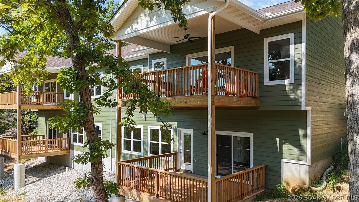 Framed by mature trees and layered decks, this is the kind of place where you naturally slow down and stay awhile. Mornings begin with coffee on the covered deck, tucked into the trees, while glimpses of the lake peek through in the distance. By evening, the space shifts, catching soft light and quiet views that make it hard to head back inside. Inside, the spacious open layout flows effortlessly over laminate hardwood floors. The kitchen anchors everything, with a large island that becomes the natural gathering spot, surrounded by clean finishes and warm textures. Conversations carry easily into the living area, where a sleek fireplace adds just the right touch of comfort and warmth. The main level brings everything together, while the lower level adds flexibility for guests, movie nights, or extended stays. With multiple decks, there’s always a place to step outside, whether you want sun, shade, or a quiet moment in nature. Set within Timberlake Village Estates, this townhome offers low-maintenance living with access to a pool, clubhouse, and community spaces, all within the School of the Osage district. It’s a home that feels easy, elevated, and designed for relaxed lake living.