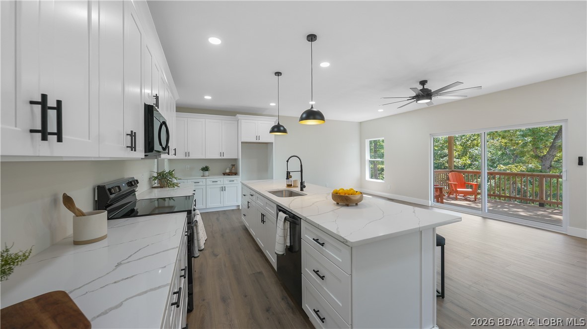 TOP-RANKED SCHOOL OF THE OSAGE DISTRICT—LIKE-NEW CONSTRUCTION, EXCEPTIONAL SPACE AND PRICED TO SELL! Designed for full-time living, this spacious, move-in-ready home offers contemporary finishes and flexibility for multi-generational living, working from home or hosting guests. The open-concept main level features a generous kitchen with oversized island, living area with fireplace, primary en-suite, second bedroom, guest bath and laundry. Multiple decks overlook mature trees and offer seasonal lake views. The finished lower level includes a large second living area, built-in bar with quartz countertops, guest accommodations and a bonus room ideal for a fourth bedroom, office, media room or gym. Timberlake Village Estates offers a community pool and clubhouse, with convenient access to Osage Beach, Lake Ozark, Eldon and Jefferson City. Just 7 miles from the Bagnell Dam Strip and less than 5 minutes from LOTO Marina, this home delivers outstanding space, location and value. BOOK YOUR PRIVATE SHOWING TODAY!