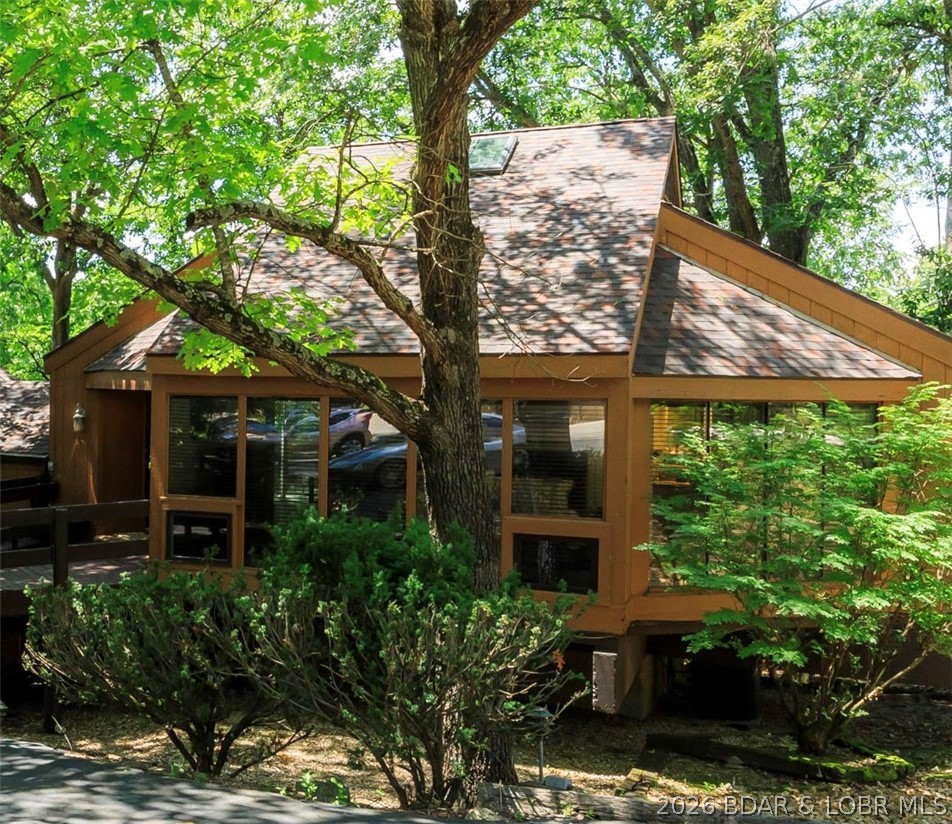 Tucked among mature trees, this unique beautifully updated turnkey Chalet villa offers a sweeping panoramic view of the 15th fairway on the Four Seasons Golf Course-perfectly blending privacy w/a picturesque backdrop. A fresh crisp interior w/an abundance of windows that flood the home w/natural light & highlight the architectural design all complimented by the subtle hints of wood. Open concept main level is the ultimate space for gatherings, the new kitchen was thoughtfully designed w/new stainless appliances, tile backsplash & marble bar/granite countertops. The bright cozy loft area is extremely versatile-perfect for relaxing or reading & is complete w/it's own skylight. With 2 walls of windows the primary bedroom feels like you're waking up in your very own modern tree house, its both a stylish & comfortable space. The lower level family room or bedroom can be turned into anything your heart desires. Tons of updates-new carpet, flooring, int. paint, vanites, sinks, mirrors, main floor shower, HVAC, in 2023 new roof & MORE! This charming home combines peaceful scenery and is conveniently located to everything the lake has to offer-nightlife, restaurants, shopping and a marina.