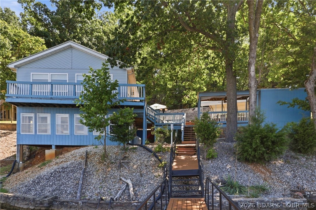 Welcome to the peaceful Little Niangua Arm. Whether you're looking for a weekend getaway, vacation rental, or full-time lake home, this 3-bedroom waterfront property offers the space, setting, and amenities to start enjoying the Lake from day one. Sold fully furnished, it’s a true turnkey opportunity ready for family, friends, and plenty of lake memories. In addition to the three bedrooms, the spacious sunroom provides flexible extra sleeping space for daybeds, bunks, a pull-out sofa, or whatever you need to accommodate a house full of family and friends. Multiple decks and outdoor gathering areas offer plenty of room for everyone. Enjoy morning coffee, fire up the grill, entertain guests, or simply relax and take in the beautiful panoramic lake views. Follow the walkway to your private, deep-water 2-slip dock and spend your days boating, fishing, swimming, kayaking, or paddleboarding. You'll enjoy calmer water and a laid-back atmosphere on the west side, with convenient access to groceries, shopping, great restaurants, entertainment, and all the fun Lake of the Ozarks has to offer.