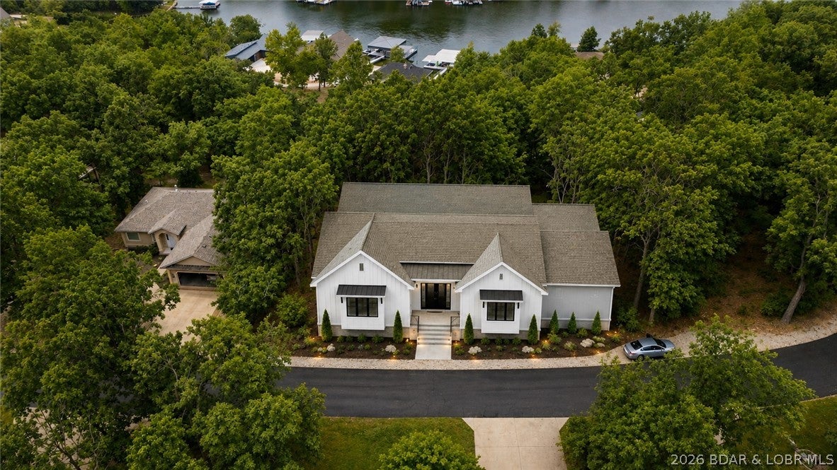 Build your Lake of the Ozarks getaway on this **second-tier lake view lot** in Timberlake Village. Positioned on a well-maintained blacktop road among quality-built homes, this homesite offers community water, community sewer, and electric already available, making it an excellent opportunity for your primary residence, vacation home, or investment property. **Building plans have already been professionally designed and are available to the buyer, offering a head start on the building process.** Enjoy lake access through the subdivision's community docks and take advantage of resort-style amenities including a community pool, fitness center, playground, and additional recreational spaces. The lot offers lake views while providing convenient access to boating, fishing, and all the outdoor activities Lake of the Ozarks is known for. Whether you're ready to build now or in the future, this property combines available utilities, desirable amenities, and a sought-after lake lifestyle in an established neighborhood.