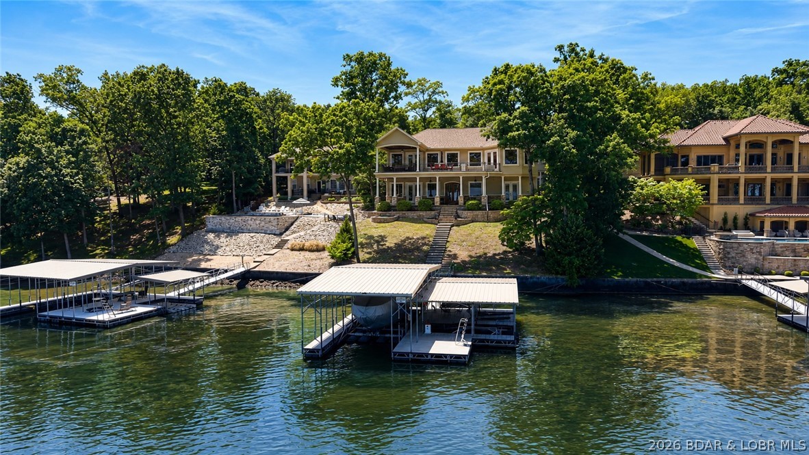 Experience lakefront living at the 17MM in the prestigious Porto Cima, Sunrise Beach. This home features an open layout with Southern charm on both levels, offering two spacious living areas, two well-appointed kitchens, and a primary suite on each level with a full bath and ample closet space. Two spacious guest bedrooms, a non-conforming bedroom or office, laundry room, and attached 2-car garage complete the home's comfortable design. Large windows and double doors fill the home with natural light and provide convenient access to the lakeside patios. A cozy fireplace and projector with big screen create the perfect space for entertaining while enjoying beautiful lake views. Outside, enjoy a gentle driveway, paved sidewalk, mature trees, and an easy walk to the dock with space for boats and PWC's. Located in the sought-after Porto Cima community, this property also includes access to Four Seasons amenities, offering the perfect blend of lake living, recreation, and convenience.