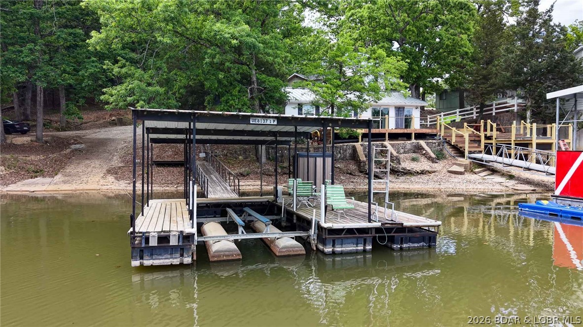 DON'T BUY A CONDO! BUY THIS INSTEAD! This home offers WATER FRONTAGE, PRIVATE DOCK, and GARAGE! This could make a great starter place at the lake for a full timer or vacationer!  Escape to this charming retreat nestled by the water's edge, TURNKEY! Great location at the 10MM. This delightful home offers a private dock, 2 bedrooms, 1 bathroom, & charming living area with lake views. It's perfectly sized for cozy getaways. Fully furnished, this property provides instant relaxation from the moment you arrive. The property has a community boat ramp in addition to a private dock with a remote boat lift just steps from the back deck. The hardy board siding and newer roof ensure this will be a low-maintenance property for years to come! With no HOA or rental restrictions, this property provides a great investment opportunity or family getaway at the lake! Now is the time to take the plunge on your very own piece of paradise at Lake of the Ozarks!  '94 Larson RXI dual prop, V8 boat & trailer in good condition is available to purchase with the home for additional. $7,500.