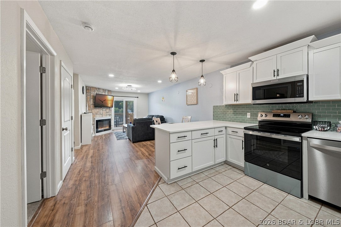 Stunning condo tucked away in a cove-view, 12-unit complex at the 3MM! This beautifully updated 2 bed, 1 bath unit features a brand new kitchen with stainless steel appliances and quartz countertops, a brand new bathroom with a walk-in shower, and a brand new deck with amazing views, accessible directly from the primary bedroom! Enjoy the open floor plan, cozy electric fireplace, and new carpet in the bedrooms. Sold fully furnished and move-in ready! Includes a 10x30 boat slip and lift for effortless lake access. Conveniently located on the lower level, just steps down from parking. Bonus is that the HOA is very reasonable  at $193 and covers your water, sewer, trash and internet. Cant beat that! Makes this lake condo very affordable. Complex just got a new roof too. Across the cove from Boathouse Lakeside Bar & Grill and minutes from the Bagnell Dam Strip. Would make a great nightly rental!