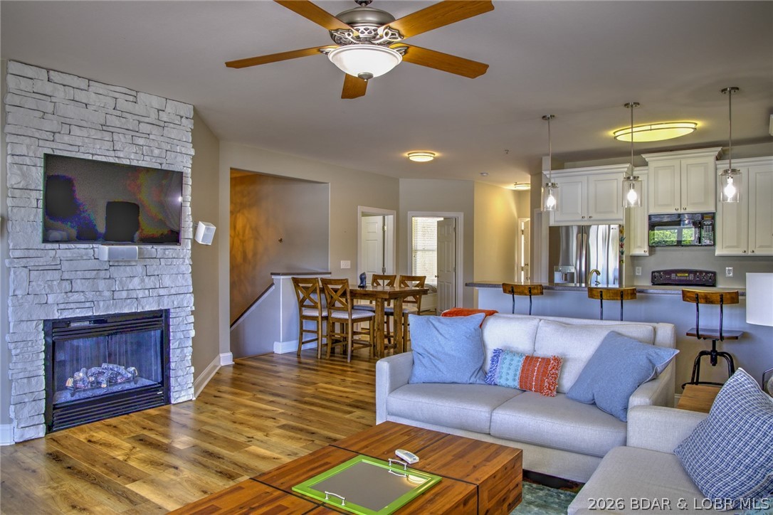 Room for everyone--this 2 story 4 Bed 4 Bath 2,300 sq ft waterfront condo offers elevator access, a 44’ covered cruiser dock, and panoramic lake views from one of the most desirable locations at the lake. This patio level corner condo features a covered deck & walkout patio with direct access to the pool and dock and elevator access. LVP floors throughout provides easy maintenance for fun water activities. The kitchen has white 42” upper cabinets, stainless steel appliances, & solid surface top opening to an inviting living room with fireplace and generous seating. The condo features 2  en suites with beautiful water views,  large walk-in showers, dual vanities, & walk-in closet. The patio level gives you & your guests a great place to relax with a full wet bar and plenty of room for your favorite indoor activities. Lots of great storage typically unheard of in a condo.  Offered turn-key furnished including 44’ x 16’ covered dock plus optional adjacent 44’ additional slip. New HVAC on the patio level in 2026. Enjoy a resort-style community with lakeside pool, ideally located near the dam, "The Strip", dining, shopping, and adjacent to Ozark Yacht Club for breakfast and lunch.