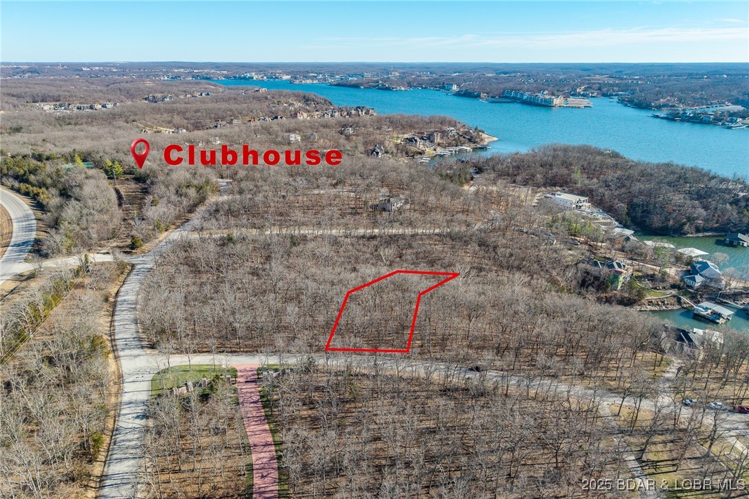 Surrounded by mature trees and natural Ozarks beauty, this wooded lot at The Villages at Shawnee Bend offers a peaceful, private setting within one of Lake of the Ozarks’ most distinguished communities. From the moment you arrive through the grand waterfall entrance, the neighborhood’s upscale character is clear. Residents enjoy access to a beautifully appointed clubhouse, resort-style community pool, championship tennis courts, and pickleball facilities, along with parks, and playgrounds. Paved roads and underground utilities make building seamless while preserving the natural landscape. Ideal for a custom home or lake retreat, this wooded homesite blends serenity, luxury, and an active lake lifestyle.