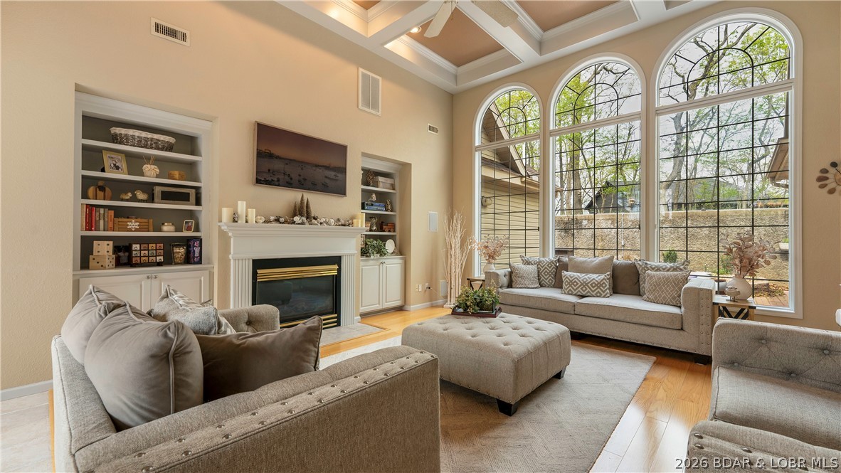 Upon entering this 4 bed nearly 2700sqft one level home, you'll first notice the massive 14ft ceilings and large window wall creating an impressive first impression. The living room creates a perfect entertainment area with lots of natural light from the 10ft tall window feature. You'll also find a gas fireplace and built in surround sound. The primary bedroom is spacious with attached en suite offering his and hers closets, his and hers vanities, and a jetted tub. On the primary suite side ther's also an office or 2nd bedroom with half bath. Off the kitchen is a breakfast nook and access to a 3 seasons room leading to the patio. Bedrooms 3 and 4 share a jack and jill bathroom. There is an ample sized laundry room and a bonus room great for an office, game, or hobby room. You'll find plenty of parking with the half circle drive and 3 car garage. Top it off that this home sits on a double lot adding privacy or the opportunity to add a pool! Being situated across the street from lakefront homes offers some seasonal views of the Lake. Four Seasons amenities included like the pickle ball courts and community pool just down the road. Don't miss out on this stunning Porto Cima home!