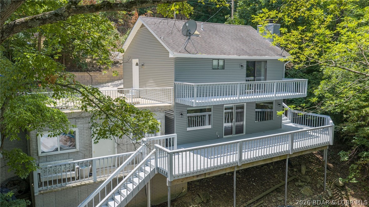 Located at the 3MM of the Big Niangua, this 3-bedroom, 2.5-bath home offers the perfect combination of peaceful cove living and quick access by boat to The Cave and other popular waterfront destinations. Thoughtfully updated, the exterior features all-new siding, upgraded decks. The main level boasts a spacious primary suite with an updated private bathroom and direct access to private  large deck overlooking the lake. You'll also find two additional bedrooms and a full bathroom with a tub/shower combination. The lower level is designed for gathering, featuring an open kitchen and living area. Outside, enjoy deep water in a protected cove with a concrete seawall, a wooden dock complete with a swim platform, and two 12' x 28' boat slips. The gently terraced landings provide excellent space for landscaping, outdoor entertaining, or creating the perfect fire pit area to enjoy evenings by the lake. Whether you're looking for a full-time residence, weekend getaway, or investment opportunity, this property offers everything you need to start making memories at the Lake. Call for a private showing today!