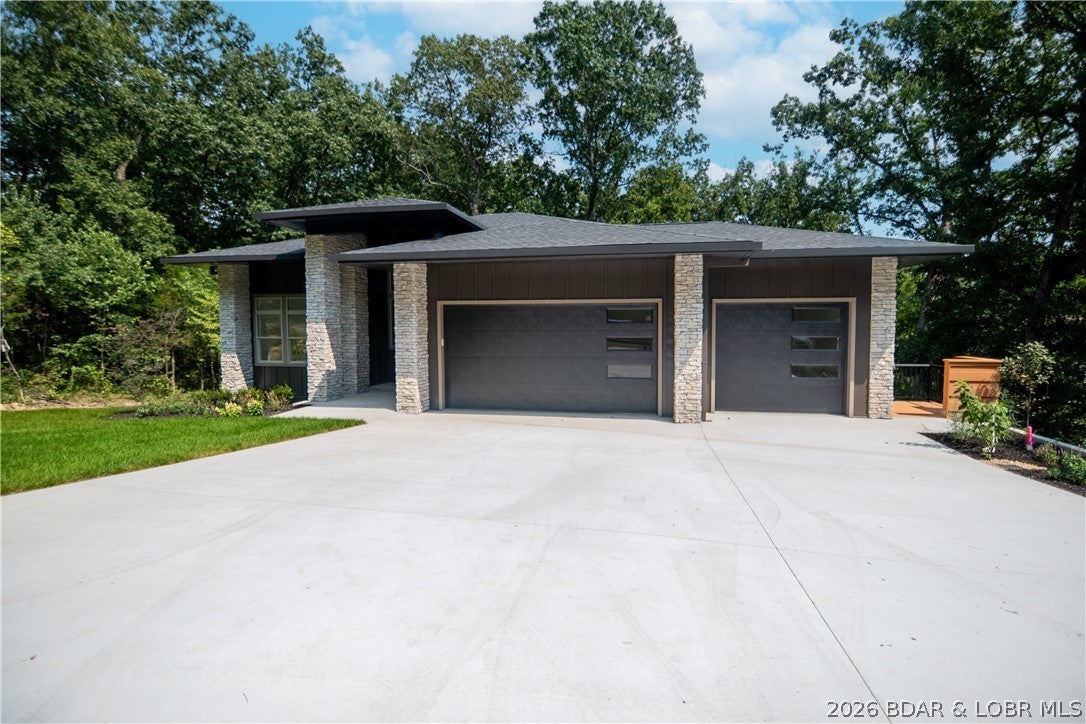 Modern design, exceptional craftsmanship and incredible flexibility come together in this stunning Osage National home! Offering approximately 3,000 sq. ft., this 3-bedroom, 2.5-bath home stands apart with quality you can see & feel throughout. The striking exterior features 24-gauge steel siding, stone accents, custom guttering & Pella windows. The beautifully finished interior is filled with natural light and upscale details including 14' entry ceilings, solid doors, 8" base trim, custom maple stairs, custom cabinetry, & Delta fixtures. Even the interior walls are insulated with cellulose for comfort/sound control. The floorplan includes a beautiful dedicated office plus an art studio complete with its own kitchenette—a versatile space that could easily become a 4th bedroom, gym, hobby room or whatever fits your lifestyle. Outside you find a fully sodded/irrigated yard, landscaping and a 3-car garage with EV charger. Located in the Osage National golf community within School of the Osage, enjoy an incredible pool, fitness center, clubhouse, driving range & 27 holes of championship golf, all minutes from Lake Ozark. Beautifully built, meticulously finished and truly move-in ready!