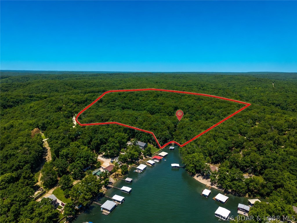 Rarely does a lake property come along that offers this combination of acreage, lakefront, privacy, and living space. Situated on approximately 24 gentle acres, this impressive 6-bedroom, 3.5-bath lakefront home creates the ideal setting for those seeking a private retreat, family compound, or estate-style property at Lake of the Ozarks. With ample room to spread out, the home offers multiple gathering spaces for entertaining, holidays and making lifelong memories. Outside, the gentle acreage provides endless possibilities for recreation, additional improvements, or simply enjoying the peace and privacy that are becoming increasingly difficult to find. Adding even more value, the large detached garage/shop provides storage for vehicles, boats, equipment, and lake toys. Major capital improvements have already been completed, including brand-new roofs and gutters on both the home and shop, along with a newer septic system, giving the next owner confidence that many of the big-ticket expenses have already been addressed. Whether you're searching for a secluded full-time residence, a family getaway, or a unique lakefront estate property, opportunities like this are few and far between.