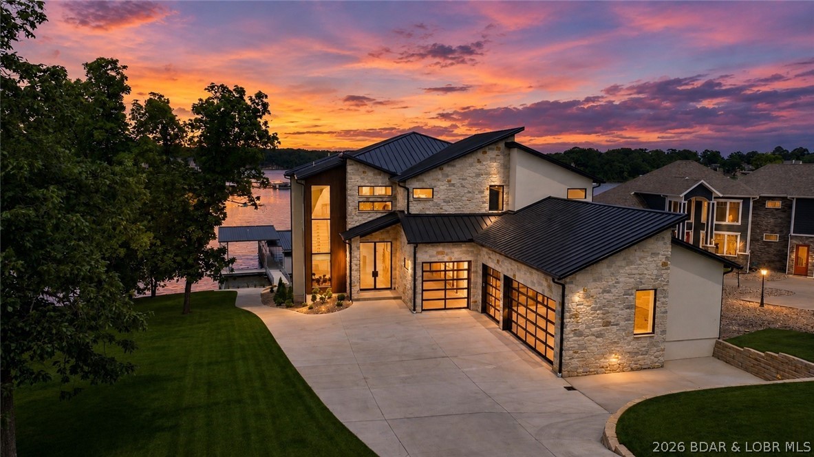 The nicest home in the most upscale subdivision at the LOZ! This ~10,000SqFt masterpiece IS COMPLETED & will leave you in awe. Centrally located on the 21MM near Redhead, Shorty Pants, & PBC. It sits on an exclusive flat, cove protected AND main channel view lot!!!   This exclusive home presents 6 bedrooms(each are ensuites), 8 full baths, 1 half bath, a 2 tiered salt water gunite pool, massive new 2 well boat dock(16x50 & 12x34 ft slips), elevator, floating staircase, & gentle lakefront lot. The exterior consists of stucco, NewTechWood, & native Kansas limstesone & marble quality limestone. The main level offers 2 ensuites, the kitchen, living, dining, & laundry rooms, & 10 ft collapsible sliding doors. Venture upstairs for 3 ensuites, bar, & a half bathroom. The lower level has a living area, golf simulator room, wine room, lakeside ensuite, storage, & walks out to the pool. Upgrades include Sonos wired speakers throughout, 4 car heated/cooled garage(fit 8 w/ lifts), each level has stamped concrete patios, Viking appliances, Quaker aluminum windows, Napoleon electric fireplaces, & was designed by ML Designs(KC's top interior designer 2022-24). Tour it today!