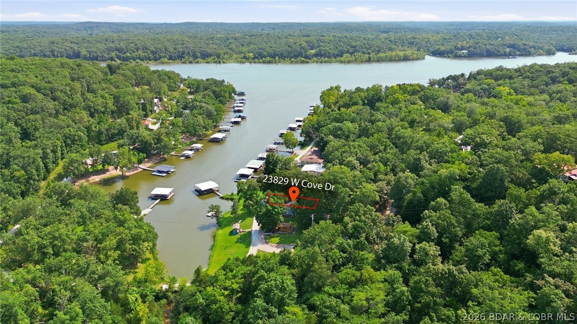 Updated 2-bedroom, 1-bath lake cottage offering low-maintenance waterfront living just a 2-hour drive from Kansas City. Recent improvements include new roof, new exterior paint and deck stain, new decking on the pier, new water heater, updated plumbing and water pump, new LVP flooring throughout, and new kitchen countertops. Large windows throughout provide abundant natural light. Private pier with 5± ft. of cove depth, ideal for boating, fishing, and swimming. Wood-paneled living and dining area, classic kitchen with modern updates, and a shaded outdoor patio complete this move-in-ready retreat. Bidding Ends September 17, 1 PM