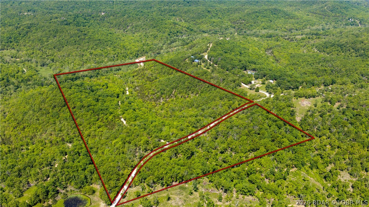 Escape to one of the most breathtaking hidden retreats in the Lake area. This peaceful 81± acre property is an extraordinary opportunity to own a private slice of the Ozarks, complete with a stunning year-round creek winding through the untouched natural land. Whether you dream of building a secluded cabin, creating the ultimate hunting getaway or simply escaping the noise of everyday life, this property offers endless possibilities. Located just down D Road from the nationally recognized Ha Ha Tonka State Park, you are minutes away from some of the best hiking, fishing, and outdoor recreation at the Lake of the Ozarks. Home to one of the largest natural springs in Missouri, the park’s crystal-clear waters help feed the entire Lake and create the incredible scenery this area is known for. The land itself is loaded with character, featuring mature timber, abundant wildlife, rolling terrain, and gorgeous creek rock that could be utilized for trails, roads, or future improvements throughout the property. Privacy and serenity are unmatched, yet you are still conveniently located only minutes from Camdenton and 25 minutes from Osage Beach. A true Ozark paradise waiting to be discovered.