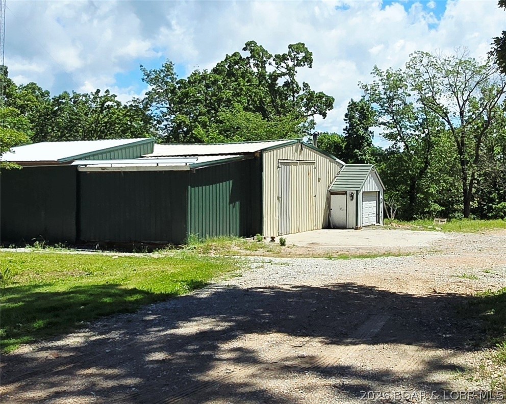Versatile 1.26-acre opportunity offering endless possibilities! Formerly home to a diesel mechanic shop, this level property features a 1,300+ sq. ft. shop with a 10'x20' automatic sliding door, two 16'x10' overhead doors, vehicle lift, and ample parking for equipment, trailers, inventory, or fleet vehicles. Also included is a 1 bed/1 bath tiny home ideal for office space, manager's quarters, rental income, or a live/work setup -inside of a fully fenced yard. The home features three mini-splits, on-demand hot water, EZ Step walk-in tub/shower, and washer/dryer hookups. Plenty of room around the property for additional buildings, outdoor storage, RV parking, or future expansion. Property also includes a silo, detached storage shed, free Rocket Wireless Internet (CoMo high speed is also available), and easy access to three nearby boat ramps. Community dock slips are occasionally available for lease. Ideal for contractors, automotive, service, storage, or small business operations. Motivated seller!