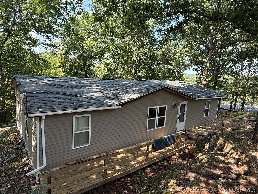 Welcome to your Lake of the Ozarks getaway! This charming 4-bedroom, 2-bath home offers 1,546 sq ft of living space, a seasonal lake view, and deeded lake access—perfect for enjoying all the lake lifestyle has to offer. The sellers have already completed a great start to the renovations, including new roof (2025), beautifully updated living, dining, and kitchen areas. The kitchen features custom wood cabinetry and granite counter tops that add warmth, character, and plenty of appeal. Outside, you’ll find a detached garage and storage shed, providing ample room for boats, water toys, tools, and outdoor equipment. Whether you’re looking for a weekend retreat, investment property, or full-time residence, this home offers incredible potential in a fantastic Lake of the Ozarks location. Don’t miss your chance to create your own piece of lake paradise!  Financing option available for qualified buyers.  Fourth bedroom does not have a closet and could be used as additional living space, like a family room.