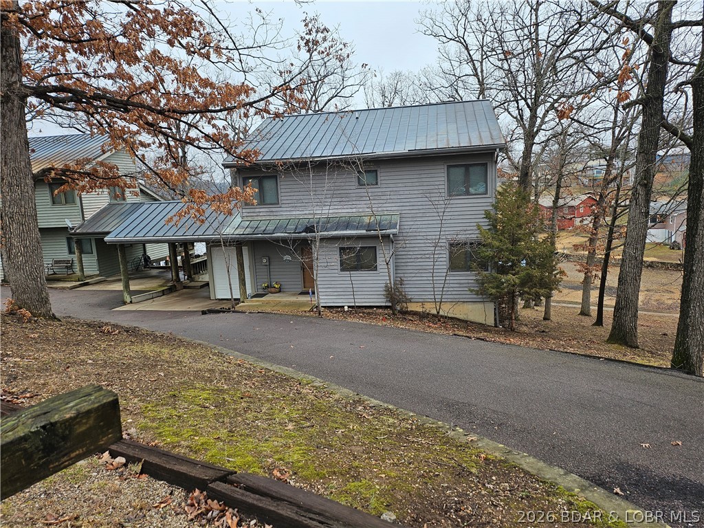 Carefree lake living with this stand alone townhouse located on the Gravois Arm.  The only connecting section to the neighboring unit  is the open carport. No connecting wall with the living spaces. It's like having your own private residence!  The main level consists of a 2-story great room with a wood burning fireplace, a large kitchen with plenty of counter space and cabinets, all appliances included, small eat-at counter in kitchen, a dining area, half-bath and laundry/utility room. The upper level has a master bedroom with a bath and 2 guest bedrooms with a hall full bath in between them.  The walkway overlooks the great room. There is a carport for your vehicle and a small storage shed with a garage door for your lake toys and other items. There is currently a golf cart in there which is available for extra $$$. Circle drive off of the main road to access the unit and more parking. To round out the package is a 12x32 boat slip in the community dock which is located on the other side of the street.