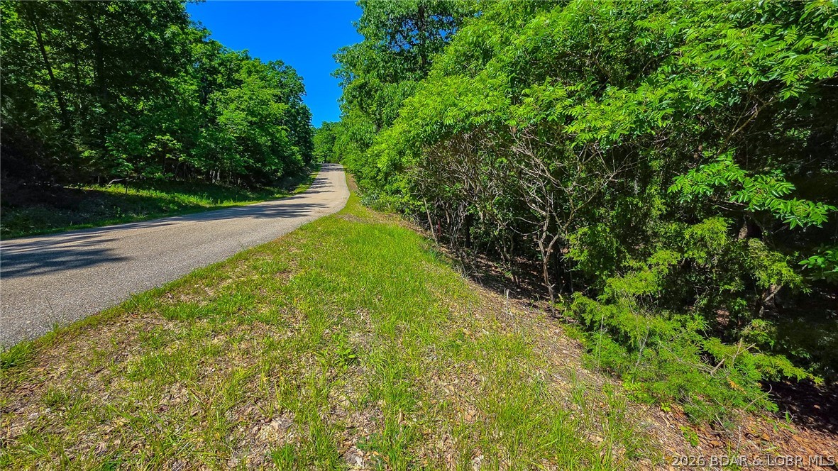 Rare Opportunity on the Signature 4th Hole in Porto Cima! Build your dream estate on this premium, 0.69-acre golf-front lot boasting mature hardwoods and incredible privacy. Situated directly on the iconic Jack Nicklaus Signature Course, this property seamlessly blends elite club living with the natural beauty of the Lake of the Ozarks. Skip the headache of development hurdles—water and sewer agreements are already firmly in place. As part of the prestigious Porto Cima community, you’ll enjoy unparalleled amenities, including exclusive lake access, sparkling community pools, tennis and pickleball courts, and playgrounds. Don't just build a home; invest in a lifestyle. Schedule your walk-through of this premier lot today!