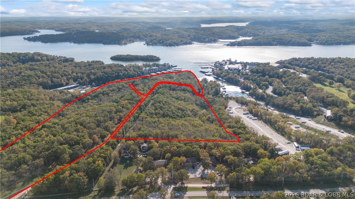 Spanning 54 acres with approximately 2,800 feet of prime lake frontage, this former KK Ranch offers a rare development opportunity at Lake of the Ozarks. Adjacent to Margaritaville Resort Lake Resort Lake of the Ozarks, the property is ideal for a luxury residential community, resort, mixed-use destination, or private estate.
Its favorable topography and expansive shoreline support multiple home sites, townhomes, and waterfront residences. Currently zoned residential with potential for commercial rezoning, it offers exceptional flexibility. Existing improvements include septic systems, water, electric, community docks, and a seawall.
Located at the sought-after 26 Mile Marker, this landmark property combines significant acreage, extensive shoreline, and a premier location—creating an outstanding opportunity for developers and investors.=