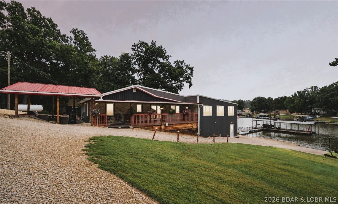 Experience premier lakeside living at MM 57 in this beautifully updated waterfront home, perfectly positioned in a quiet no-wake cove offering calm water, privacy, and protection from main-channel waves. This 4BR, 4BA residence features a 3-car garage, new wiring, new siding, and a flexible dual-section layout ideal for private guest quarters, multi-generational living, or even three separate Airbnb setups. The main living area showcases fantastic lake views, creating a stunning backdrop for everyday living. Outdoors, enjoy lakeside entertaining—add a small deck at the water’s edge or use the expansive existing deck with a constant gas line to the outdoor kitchen. South-facing exposure provides excellent natural light and winter warmth. Only 950 ft of gravel from all paved roads. Premium utilities include community water, a top-tier septic system, and reliable COMO electric and internet. Waterfront amenities include zero stairs to the shoreline, two private boat ramps, and consistent water depth-deep enough to float a V Bot, when the lake is down. Excellent fishing with established crappie beds completes this rare offering of convenience & quiet-water living.