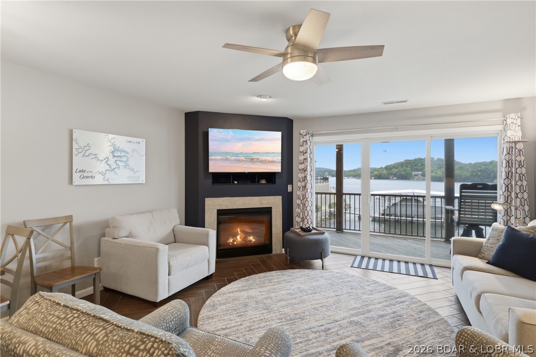 Beautifully updated waterfront 3 bed, 2 bath condo with a 12 x 32 slip and 12,000 lb hoist in Clearwater Condos, located at the 8.5-mile marker of the Big Niangua in Camdenton @ Lake of the Ozarks. Enjoy stunning main channel views from this unit, which features a kitchen with new Hanstone Quartz Italian Wave countertops, SoHo Vintage Gray tile backsplash, new undermount sink & faucet, cabinet pulls, slow-close hinges, & a newer refrigerator w/ ice maker. Family room boasts gorgeous Herringbone custom tile flooring, a sofa sleeper, corner gas fireplace, & a sliding glass door leading to a large screened-in deck with vinyl siding & ceiling fans new within the past year. Owner’s suite has its own slider to the deck, walk-in closet,  & private bath with dual sinks, updated faucets, towel bars, cabinet pulls, & elongated toilet. 2 additional bedrooms, a 2nd full bath,  & laundry area are down the hall, with newer carpet & upgraded pad in all bedrooms & hallway. Most furniture is newer within the last 2–3 years. Community amenities include a pavilion with firepit, playground, two pools (one heated), and pet relief stations. PWC slips available to purchase, unit has never been a rental!