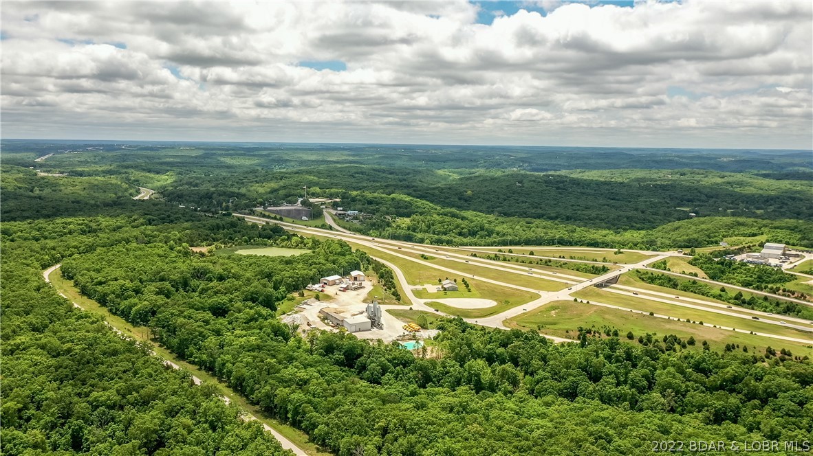 Lake of the Ozarks is growing rapidly. This is 348 acres of prime development ground located perfectly between Camdenton and Osage Beach at one of the few US 54 Expressway interchanges. You just can't find many large tracts of land for sale with this type of location and this opportunity. US Hwy 54 Expressway frontage directly across from Big Surf Water Park, just outside Osage Beach city limits. Easy accessibility, great visibility and an extremely high traffic count make this the perfect spot for Lake of the Ozarks "next big thing". Owner will subdivide or sell as listed package and let a developer control the whole piece. Perfect piece of ground for mixed use with commercial and residential.  Topography lends itself well to possibly make some beautiful lakes.  Big Surf waterpark is now called Supersplash USA (which is being renovated) and this property is in close proximity to Supersplash and the recently released Pinseekers!