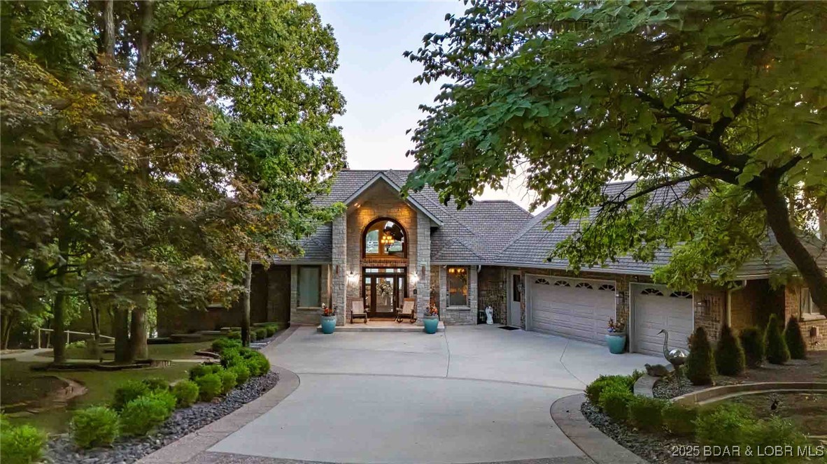 Amongst a canopy of trees in the most serene of settings 387 Stonebridge Ln. reveals itself as you enter your own gated driveway flanked with sustainable natural landscaping. The exterior construction is oversized midwest red brick contrasting with white window frames and solid stone sills. The construction quality on the outside of the home continues throughout the entire home where you will find a spacious foyer, dining room and living area, a commercial kitchen, an owners suite, spare bedroom, tiled radiant heat floors, Geo Thermal HVAC system, professional A/V system, Lutron lighting and amazing lake views from nearly every room. The lower level has a bar and entertainment area as well as a second living room and 3 bedrooms one partially used as a home office. The lakeside exterior is where the fun continues, a panoramic vista with multiple levels of decks strategically separated from one another by a salt pool. An outdoor grilling area, pizza oven and a Bocce Ball Court will provide your family with years of entertainment and memories. A large 3 well dock with a breakwater are home to your boats and watercraft. For a complete list of home features please visit our attachment.