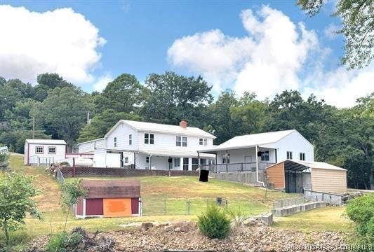 4-bed, 2-bath waterfront home in the Turkey Creek arm of Lake of the Ozarks. Enjoy lake access from your private, 2 slip dock conveniently including electric. The large, 2-car detached garage, and workshop is heated and well insulated providing the ability to comfortably enjoy working on your hobbies all year long. Don't miss out on the beautiful lake views through the new windows throughout the home! The home also boasts spacious living areas and the ease to walkout and enjoy your covered patio and large backyard perfect for outdoor gatherings. With community boat ramp and convenient access to water activities, this property combines comfort and recreation for an idyllic lifestyle.