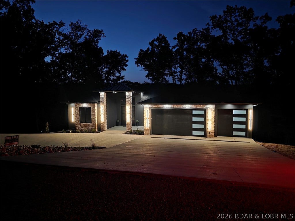 EXCEPTIONAL NEW CONSTRUCTION IN PORTO CIMA!Experience luxury Lake of the Ozarks living in this stunning custom residence overlooking the Jack Nicklaus Signature Golf Course.Designed for both everyday living and entertaining, this home features expansive windows, beautiful finishes, generous living spaces, & exceptional indoor-outdoor living. The open great room showcases a striking fireplace and flows seamlessly into the dining area, gourmet kitchen, & covered outdoor spaces.The chef’s kitchen offers Café appliances, quartz countertops, abundant cabinetry, and ample gathering space. The spacious primary suite is a private retreat with a spa-inspired bath featuring an oversized custom shower, freestanding tub, dual vanities, and impressive walk-in closet. The finished walkout lower level provides a family room, game room, additional bedrooms and baths, plus flexibility for another bedroom.Quality construction includes 2x6 walls, Andersen windows, hard stucco, cultured stone and steel siding, wood flooring, extensive tile, and quality fixtures. The oversized three-car insulated garage has hot/cold water and floor drains.Irrigation and a circular concrete drive complete the property.