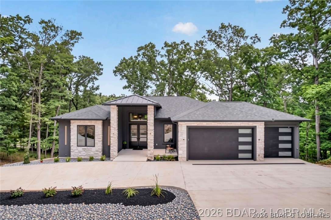 Experience luxury golf course living in this brand new custom-built home overlooking the prestigious Jack Nicklaus Signature Golf Course at Lake of the Ozarks. Built with quality in mind, this residence features durable 2x6 exterior construction with a striking combination of hard stucco, cultured stone, and steel siding. The open floor plan showcases an impressive great room anchored by a commanding fireplace and expansive windows capturing beautiful golf course views. The kitchen features premium Café appliances, a double oven plus wall oven, and gorgeous quartz countertops. Retreat to the luxurious primary suite offering a spa-inspired bath with an oversized custom shower, soaking tub, dual vanities and a huge custom walk-in closet. The large covered deck provides the perfect space for relaxing or entertaining. Additional highlights include a 3-car garage w/hot & cold water, two floor drains, irrigation system, and an enormous circular concrete driveway. The lower level offers room to add an additional bedroom. Combining superior construction, upscale finishes, and an exceptional golf course setting, this stunning new home delivers the best of Lake of the Ozarks living.