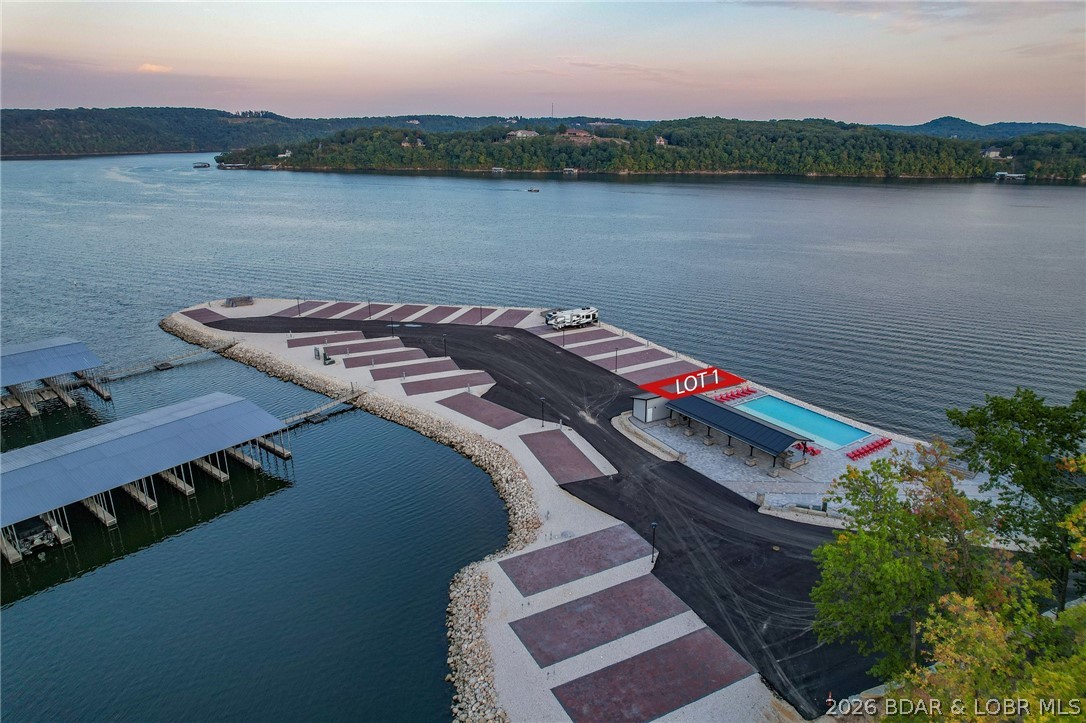 Welcome to Paradise Point RV Resort—one of the most exciting opportunities to own at the 38MM of Lake of the Ozarks. Set on a stunning peninsula with incredible panoramic views, this development offers both lakefront & second-tier RV lots now available for individual purchase. Every site is built right—level concrete pads with full hookups including 100-amp electric, water, sewer, and Wi-Fi—designed for comfort, convenience, & long-term value. An  HOA ($200/month) keeps the community maintained and looking sharp. The amenities set this apart: lakefront pool, sandy beach, swimming dock, marina with boat slips available, covered pavilion with grills, large stone fire pits, bathhouse with laundry, and fenced dog park. Whether you want to relax or entertain, it’s all here. Leave your RV on-site year-round and skip the hassle of hauling. When you’re not using it, rent it out for additional income—strong demand makes this a smart investment as well as a lifestyle play. Located in Sunrise Beach with easy access by land and water, this is lake living without the typical price tag or maintenance. Multiple lots available with varying prices—secure your spot now before they’re gone.