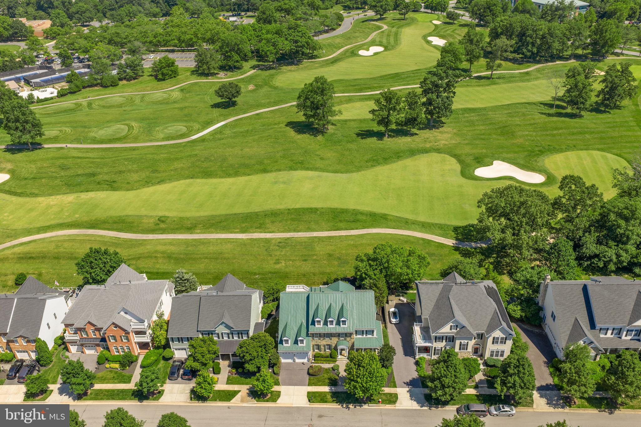 Experience luxury living with breathtaking panoramic golf course views from this exceptional former model home in Lansdowne on the Potomac. Set on a premier golf course lot overlooking multiple fairways of the Robert Trent Jones-designed course, this residence enjoys one of the community’s most coveted settings. Perfectly positioned along the 9th hole with additional views of holes 1 and 10, the property offers a spectacular backdrop from nearly every room.

The stunning stone-front exterior, wrap-around porch, and standing-seam metal roof create unforgettable curb appeal and set the stage for more than 6,000 square feet of beautifully designed living space. Offering five bedrooms, four and a half baths, and three finished levels, this exceptional Coton model with extension seamlessly blends luxury, comfort, and timeless elegance. Multiple outdoor living spaces include a four-season room addition, expansive Trex deck, private terrace off the owner’s suite, paver patio, and professionally maintained grounds with irrigation.

A dramatic two-story foyer welcomes you with marble flooring, an elegant oak staircase, and hardwood floors that flow throughout much of the main level. Formal living and dining rooms with a butler’s pantry provide elegant entertaining spaces, while the private office overlooks the golf course and features French doors, a bay window, and a dramatic two-sided fireplace shared with the family room. Extensive crown molding, decorative niches, arched openings, and custom millwork showcase the home’s exceptional craftsmanship throughout.

The sunken family room serves as the heart of the home, featuring one of four fireplaces, custom built-ins, and a wall of windows framing breathtaking golf course views. The gourmet kitchen is designed for the discerning chef and offers cherry cabinetry, granite countertops, a large center island, Wolf six-burner gas cooktop with double ovens, stainless steel appliances, a planning desk, walk-in pantry, and abundant storage. The kitchen flows seamlessly into the breakfast area, family room, and four-season room, creating the ideal setting for everyday living and entertaining. A convenient rear staircase provides easy access to the upper level.

The adjoining four-season room offers panoramic golf course views and direct access to the outdoor living spaces. The expansive Trex deck overlooks the fairways and beautifully landscaped yard, while a private paver patio tucked beside mature hedges creates a peaceful retreat for relaxing or entertaining.

Upstairs, the luxurious primary suite serves as a private sanctuary, featuring a sitting room with built-in shelving and fireplace, a wet bar with custom cabinetry, a spacious walk-in closet, and private terrace overlooking the golf course. The spa-inspired bath offers separate vanities, a soaking tub, and a walk-in shower.

Three additional upper-level bedrooms provide exceptional flexibility for family and guests, including a junior suite with a private en-suite bath and walk-in closet. Bedrooms three and four share a Jack-and-Jill bath.

The finished walk-out lower level is designed for recreation, entertaining, and multigenerational living. Highlights include a large recreation room with stone fireplace, pool table area, full wet bar with beverage refrigerator, dedicated media room with projector and screen, home gym, legal fifth bedroom, full bath, and direct walk-out access to the backyard and paver patio.

The estate is being offered fully furnished, including select furnishings, artwork, the grand piano, pool table, media room equipment, and fitness equipment. Please contact the listing agent for a complete list of included items and exclusions.

Residents enjoy an exceptional resort-style lifestyle with access to indoor and outdoor swimming pools, a fitness center, tennis and pickleball courts, playgrounds, walking and biking trails, sport courts, canoe and kayak launch, outdoor amphitheater, and a popular summer conce