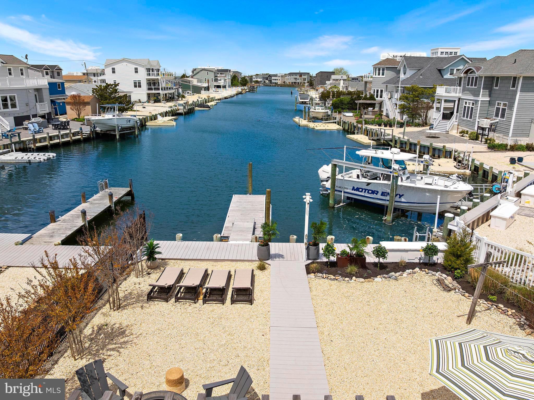 Direct LBI WATERFRONT coastal-chic stunner in the boater's paradise of High Bar Harbor!  57 Auburn is a complete showstopper in every way.  This impeccably maintained 3 bedroom residence sits on a gorgeous 80 x 107 lot, with magnificent, long water views to the bay.  Inside, this designer home will surely impress, with large. open concept living/dining/entertaining space for al your family and friends. Enter to a gleaming, custom ship-lap ceiling, recessed lighting, ceramic wood-tone tile floors, and quintessential brick fireplace mantel.  Your living room flows seamlessly into the chef's grade kitchen and dining room,  with 6 burner Kutch professional range, vented range hood, carrara bianco quartz countertops, drawer microwave,  abundant shaker-style cabinetry in "villa grey",  and, of course,  stunning water and open sky views.  Even more entertaining space included, as a barn style door opens into the family room,  with vaulted ceilings, skylight, and large French sliders opening onto your professionally created outdoor oasis!  The grand backyard is brilliant, featuring a custom Reynolds  timber pergola, extensive hard/landscaping,  as well as multiple seating, dining, sunbathing, and entertaining areas.  A maintenance free composite walkway leads to your beautiful, new, IPE floating dock and bulkhead with two slips for all your water toys, boat, and jet skis (plus swimming and crabbing, of course).  The coolest separate cabana contains and outdoor bar, bunk beds,  and tv/audio......the quintessential "man-cave" or "she-shed." Beautifully renovated baths, central HVAC, EV charging station,  full size W/D, and pool ready.  A spectacular opportunity to purchase a turn-key, custom waterfront property for a lifetime of memories!