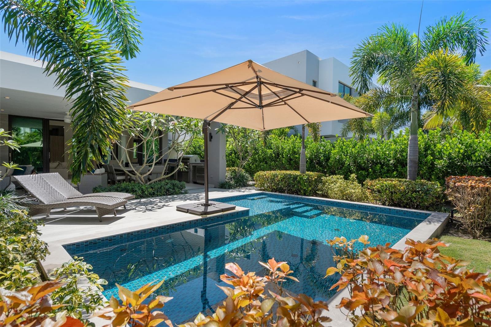 This beautifully curated one-story residence is a private tropical retreat, set on an 883-square-meter lot with approximately 3,550 square feet of gross construction and 2,500 square feet of conditioned living space in the The Isles, a community within the Dorado Beach Resort and Club. From the moment you arrive, the home feels like a beach sanctuary where mature landscaping surrounds the property, creating a sense of privacy and tranquility that feels both natural and established. Designed for seamless indoor-outdoor living, the residence opens to a resort-style outdoor area featuring a fenced in yard, private pool, covered terrace, outdoor shower, and built-in BBQ kitchen space including a Wolf Grill, perfect for entertaining. A double-car garage plus a separate golf cart garage adds convenience and functionality to take you within the 2,700 acre resort. Inside, the home reflects a refined yet relaxed beach aesthetic, thoughtfully curated with designer wallpaper, elegant lighting fixtures, and elevated finishes throughout. The interior design vision, guided by renowned Puerto Rico designer Caro Banazar, brings cohesion and warmth to every space, striking the perfect balance between sophistication and coastal comfort. The kitchen is both beautiful and highly functional, featuring marble backsplash detailing, a gas cooktop for the serious chef, and premium Thermador appliances. Altogether, this residence blends tropical serenity with intentional design, offering a home that feels private and polished.