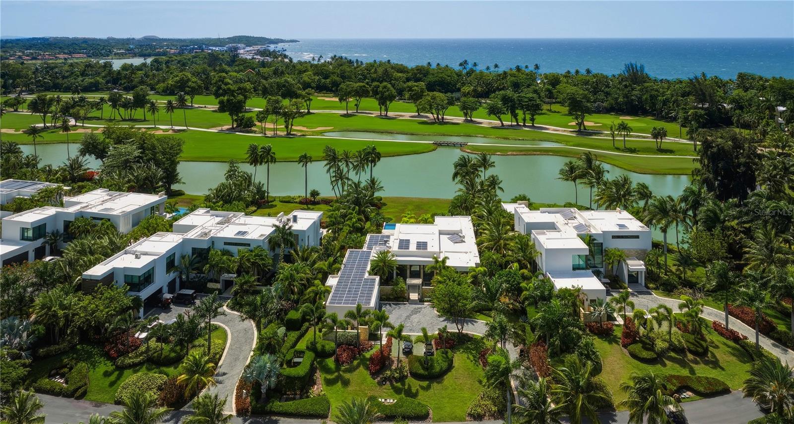 Enviably situated along the prestigious Dorado Beach Drive, 14 East Beach occupies a premier position within the sanctuary of the Ritz-Carlton Reserve Residences. Perched upon a majestic 2,807.57-square-meter lakefront estate, this residence offers an unparalleled panorama of verdant golf course vistas and serene, glistening waters. Completed in 2021 and offered in turnkey mint condition with all furniture and design conveying, this residence harmonizes the effortless blend of indoor/outdoor living. A single-level expansive floor plan, the home encompasses approx 4,100 air conditioned square feet, plus 1,500 square feet of natural sunning and living spaces, totaling an abundant 5,600 square feet. Voluminous heights throughout and floor-to-ceiling glass moveable walls invite spectacular natural light within, while a palette of exquisite natural materials foster a seamless dialogue with the lush landscape. Curated by the renowned Caro Benazzar, the interiors feature a collection of pieces from B&B Italia and Herman Miller, serving as an homage to a perfect equilibrium of tropical allure and modern sophistication. The estate offers five impressive sized bedrooms with five and a half bathrooms. Broad living areas open effortlessly into the Poliform / Flexform chef grade kitchen, while the private three car garage has been transformed into a premier wellness studio with Trackman golf simulator. Beyond its aesthetic grace, the villa boasts state-of-the-art sustainability with advanced solar systems and full off-grid capabilities. The infrastructure is further enhanced by a robust Ubiquity IT network and a comprehensive security system, complete with integrated cameras, ensuring both seamless connectivity and peace of mind. Outside, manicured gardens envelop the resort-inspired pool and terraces, offering a secluded oasis with sweeping views of the lake and emerald fairways. Fully approved second-story expansion plans envisioned by Jota Arkitekts are available to the discerning buyer. Two bespoke Garia golf carts are offered. Residents enjoy privileged access to the storied lifestyle that has solidified this destination as the Caribbean's most distinguished residential enclave. A profound expression of scale, privacy, and architectural grace, 14 East Beach at the Ritz-Carlton Reserve, represents the stand apart within Puerto Rico's most exclusive community.