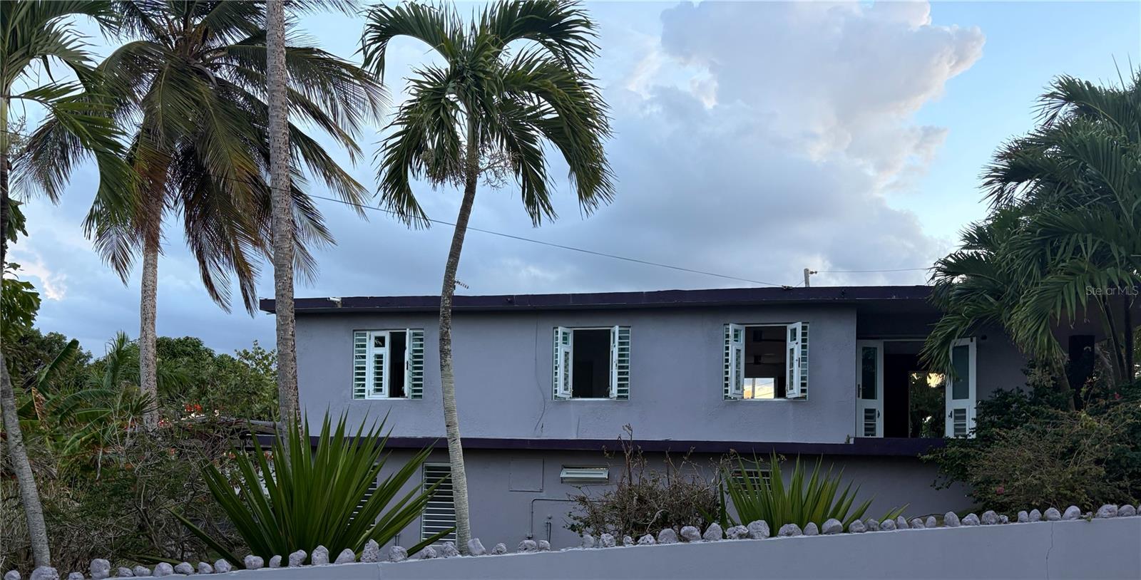 A corner coastal property offering ocean, golf course, and mountain views. 

Thoughtfully designed for flexibility, this 4-bedroom, 3-bathroom property presents an ideal opportunity as a primary residence, vacation home, investment property, or income-producing Airbnb. Just one block from a secluded natural beach, the home offers an authentic coastal lifestyle in one of Puerto Rico's most desirable municipalities.

The residence functions either as one expansive home or as two living spaces. The upper level is over 1300 SF with three bedrooms, two bathrooms, open living areas filled with natural light, and a wraparound veranda that captures the surrounding views and refreshing ocean breeze. The kitchen enjoys extra counterspace and mountain views. 

The garden level offers a fully self-contained one-bedroom, one-bathroom residence spanning approximately 786 square feet, complete with its own kitchen, living area, and private entrance ideal for guests, extended family, or rental income.

Outdoor living is equally compelling with over 7400 SF of land. The two custom-built wooden gazebos are nestled among mature tropical landscaping. Flourishing coconut palms, soursop, banana trees, flowering plants, and aromatic herbs create a lush garden setting that complements the home's solid concrete construction and enhances its tranquil atmosphere.

Located in the vibrant coastal neighborhood of Mameyal with access to some of Dorado's treasured natural attractions. Residents gather at La Pocita, a beloved oceanfront area with natural pools and cabanas, while the nearby Ojo del Buey Coastal Reserve offers 39 acres of protected shoreline with scenic trails and dramatic coastal landscapes. The neighborhood is also home to popular destinations such as Kikita Beach House - named after the popular surf beach, Kikita Beach- creating a lively yet relaxed atmosphere where dining, surfing, and community come together. Rombo is also a popular eatery down the street.  

Dorado is one of Puerto Rico's premier residential destinations.  The local beaches are well taken care of and lively; the town features a 24hr grocery store, wellness services, a variety of cuisine, and a full range of everyday conveniences, all within approximately 30 minutes of Luis Muñoz Marín International Airport.