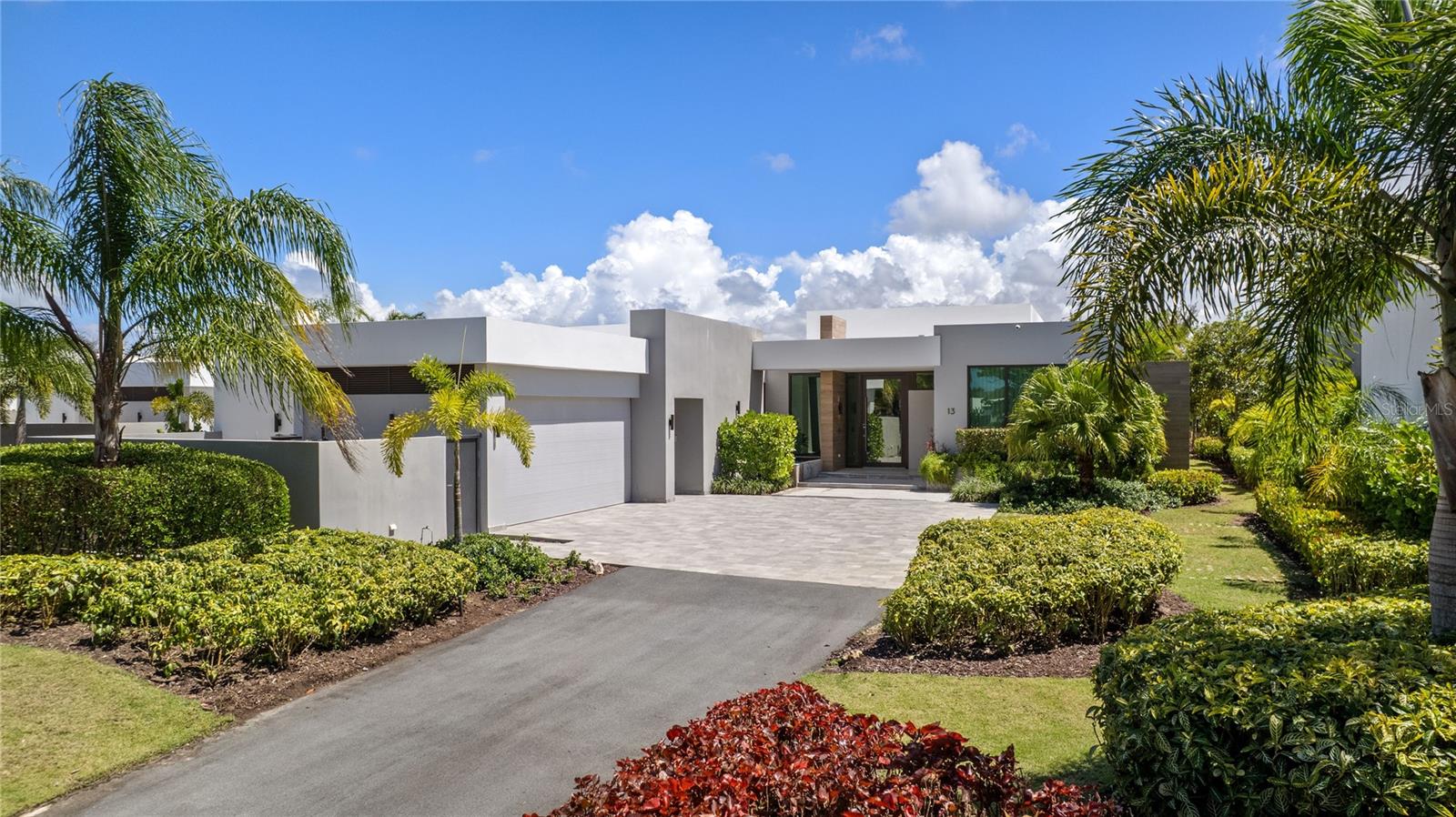 Set within The Isles at Dorado Beach Resort, this one-story residence presents an elegant expression of space, privacy, and indoor-outdoor living. Built in 2022, with 4,312 sq ft including covered terraces the home sits on a 1,451 sq mt lot, surrounded by water and open green views that define the private setting from the moment you arrive.

A double-height open layout anchors the main living area, where natural light, clean lines, and refined finishes create a sense of scale without losing warmth.

The living room, dining area, and kitchen connect in one continuous flow, opening fully to the terrace and outdoor lounge. Large sliding glass panels remove the barrier between interior and exterior, allowing the home to function as a single, extended living space.

The kitchen features a large culinary workstation and entertainment island, bespoke cabinetry, and integrated luxury appliances. It connects directly to the expansive outdoor BBQ terrace, creating an organic and natural transition for entertaining.

The residence includes four bedrooms, each with its own en-suite bathroom, plus a flexible additional room suitable for an office, media room, playroom or guest space.

The primary suite is positioned to capture open views and direct access to the outdoor areas, complemented by a spacious bathroom and a layout focused on comfort and privacy.

Outside, a covered outdoor living and dining area of 696 sq ft leads to an inviting pool deck with an infinity-edge pool and jacuzzi, all oriented toward the lake and the Dorado Beach TPC Sugarcane golf course. The landscaping frames the property while maintaining open sightlines, reinforcing both privacy and connection to the surroundings.

Additional features include a powder room, pool bath, full air-conditioning system, water softener, cistern, and a community-wide generator. The residence is offered furnished, with interiors curated by Palacios to align with the home’s architectural language.

Located within The Isles, one of the newest and most acclaimed communities inside Dorado Beach Resort, residents benefit from a gated environment with access to internal amenities including pools, tennis courts, gym, and recreational spaces. Resort membership further expands the lifestyle to include TPC championship golf courses, the Encanto Beach Club, the Watermill pool and amenities, a spa, fitness facilities, over five dining venues, the Rockefeller nature trail and an extraordinary community.

This residence combines scale, design, and location within a setting defined by water, landscape, and access to one of Puerto Rico’s most established resort communities in the Caribbean.