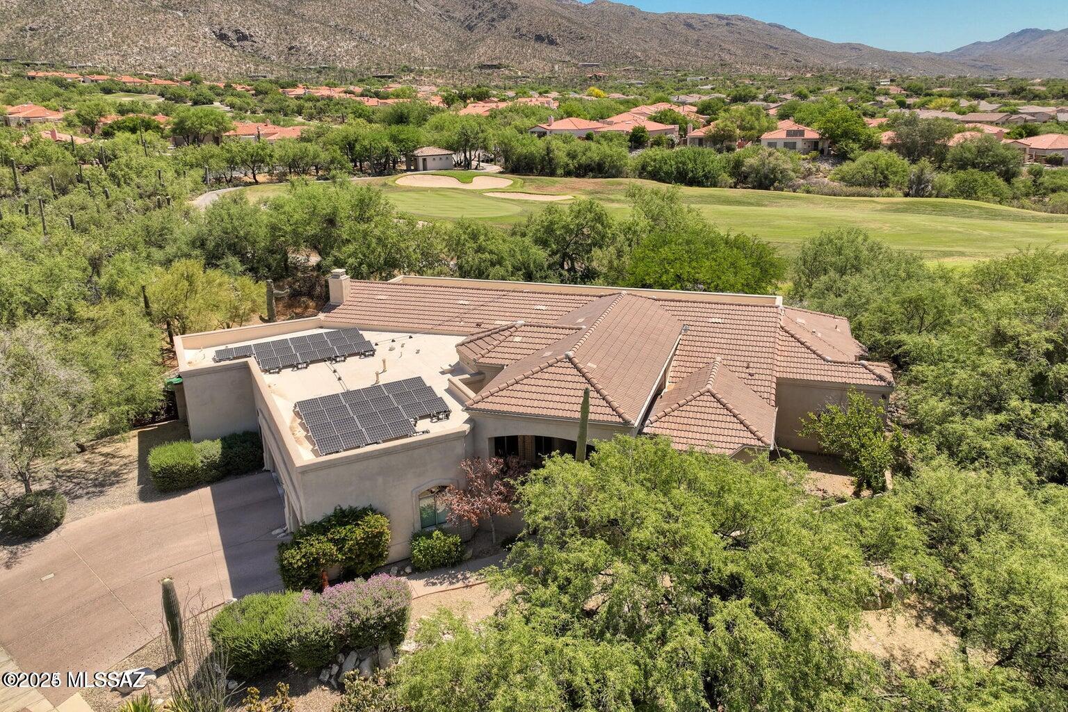 VA Assumable Loan!! Ask for details! Discover this stunning semi-custom home in the quiet, gated Sabino Springs community, offering spectacular mountain and golf course views. With 4 bedrooms, 4 bathrooms, and a 3-stall garage, this 3,377 sq. ft. home boasts elegant hickory and travertine flooring, decorative cove ceilings, and a beautifully painted interior. The spacious layout includes a separate living and dining room, a great room with a fireplace, and a gourmet kitchen with custom cabinetry, granite, and stainless steel appliances. The outdoor space features a covered patio, built-in BBQ, outdoor kitchen, and spool, all overlooking the Catalina Mountains and golf course. Current lease in place until May 2026. Do not disturb tenants.