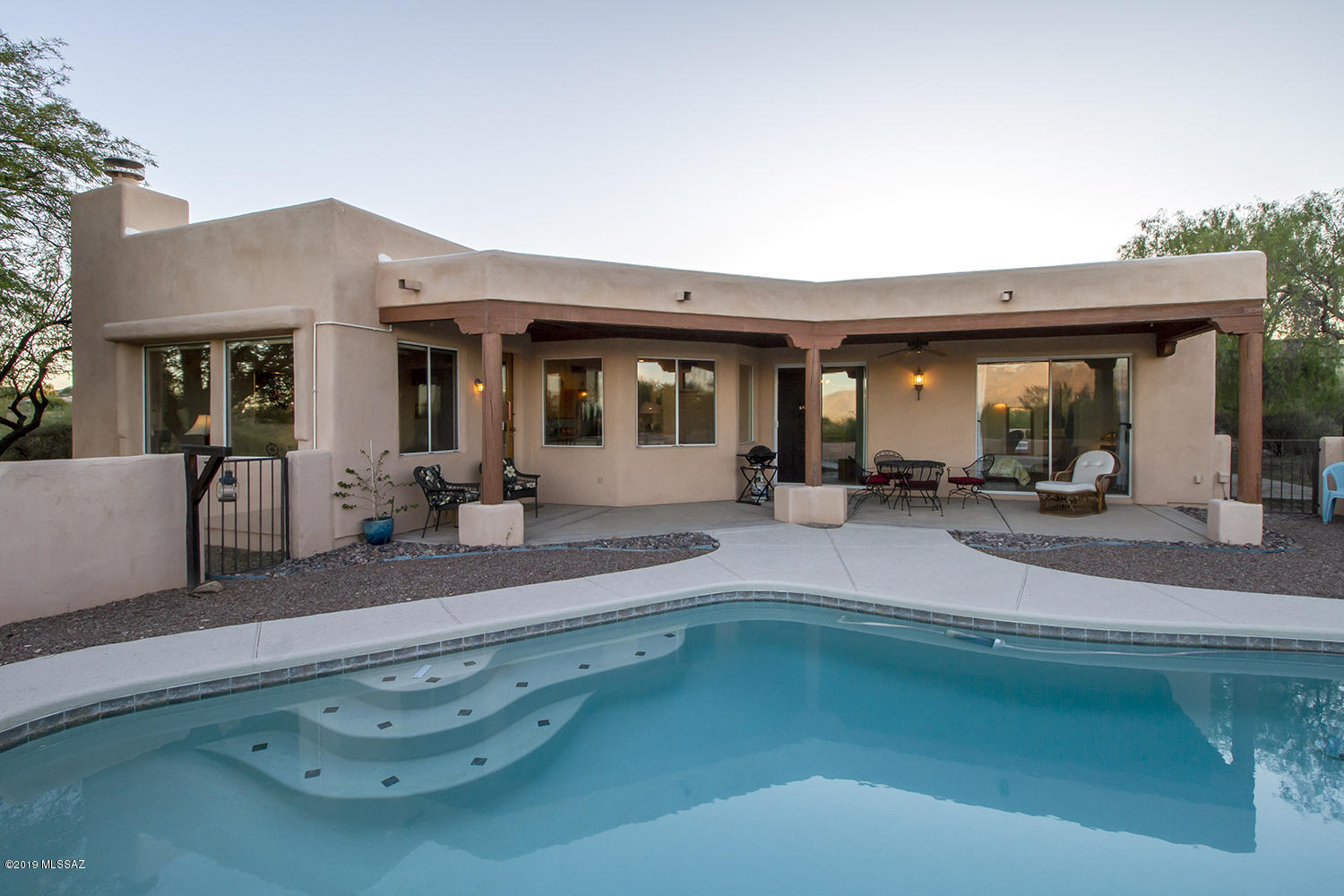 Beautiful Santa Fe style home with stunning views that sits on just over an acre.  Sit by the pool with a glass of wine and get swept away with the views of the mountain and city lights. The main house has 3 bedrooms 2 bath rooms plus a den, exposed beam ceilings and a fireplace in the living room.  A spacious eat in kitchen as well as a formal dining room, spectacular mountain views from almost every room in the house.   A nice size one bedroom 1 bath room guest house with a fireplace also in the living room.  Once you see this house you will want to call it home!