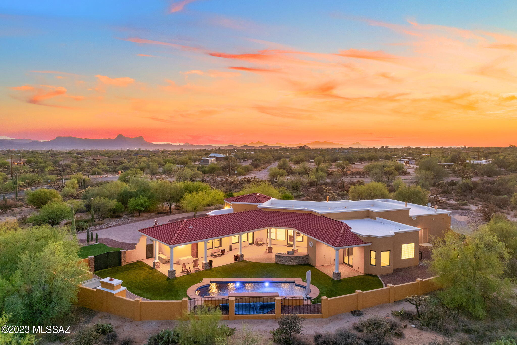 Desert Oasis: Sprawling Estate on 3.3 Acres Enveloped by Natural Desert Landscape! Step into an architectural marvel reminiscent of Spanish modern Santa Barbara style. Beyond the imposing wrought iron double gates, a fountain graces a stately circular drive, welcoming you with a warm desert embrace. Passing through the custom double iron doors, you're greeted by intricate inlaid custom tile motifs, soaring ceiling heights and spacious rooms illuminated by floor-to-ceiling windows. The heart of this abode is a kitchen that brilliantly fuses form and function. Anchoring between a formal dining room and a vast great room, it stands as a hub of togetherness. Picture granite counters glistening under ambient lighting, and stainless appliances awaiting your culinary adventures. Imagine game nights amplified on a mammoth video screen, where every scene becomes a cinematic experience and family moments take center stage.

The flow of the home brings you closer to nature; expansive windows frame the mesmerizing Pusch Ridge Mountain views, binding indoor opulence with the tranquil beauty of Oro Valley. Venture outdoors to discover fruit trees that promise nature's bounty, and a verdant turf, perfect for leisurely afternoons.

Entertainment reigns supreme here. From a sprawling covered patio outfitted with built-in speakers to a lavish lap pool accentuated with a cascading spillway, every inch beckons relaxation and revelry against a backdrop of mountain silhouettes.

For automotive enthusiasts, a commodious 6-car garage awaits, complemented by ample space for an RV, boat, or ATV. The call for adventures is ever-present.

While this 2007 jewel seamlessly integrates with its surroundings, its interiors offer a canvas for personalization. A touch of updating and new carpeting is required, a unique opportunity for you to infuse your signature style.

Embark on a journey where Spanish design meets Oro Valley enchantment. Thanks to the expansive 3.3 acres with no neighbors in sight, embrace a life of unparalleled privacy.