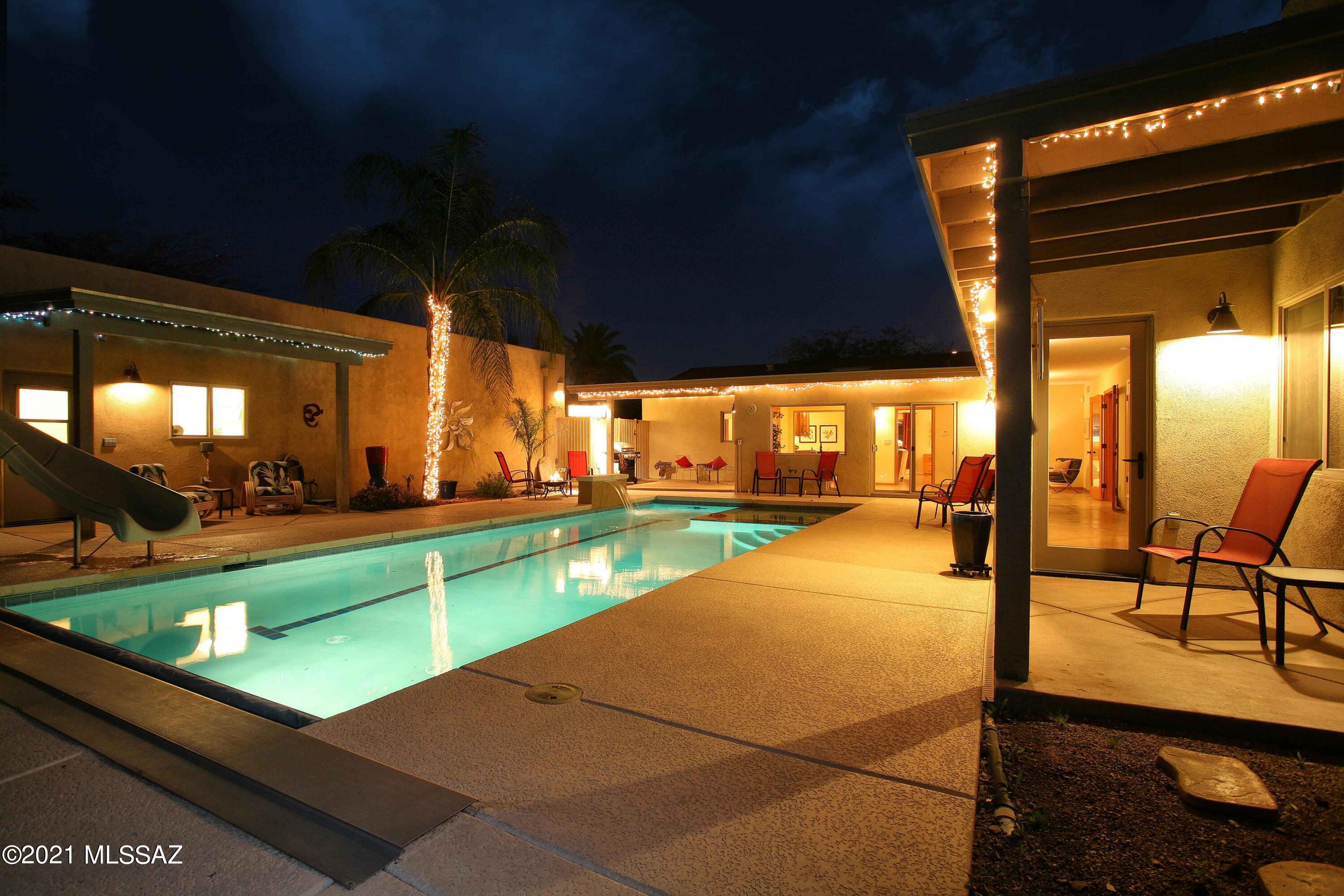 Welcome to the hidden gem of the neighborhood!  This 1946 remodeled and expanded bungalow was transformed into a unique and simply elegant, 3000 sqft home in 2007.  Thoughtful design, hand crafted cabinetry, upgraded finishes, and inviting resort-like pool/spa create a private and comfortable home to enjoy while still having quick access to city amenities.   
As you enter the home you'll notice that natural light abounds in every space.  The original front of the home features a living area  open to the dining area with a wall of beautiful clear alder cabinetry and glass panel doors, hand crafted and with a granite-topped buffet, as the focal point.  The shelves and buffet are illuminated from above.  Step into the gourmet kitchen from the dining area and note the abundance of storage built into the knotty alder cabinets.  All the pantry shelves and lower cabinet shelves conveniently roll out for easy access.   The top of the line stainless steel appliances (Subzero fridge, GE Profil gas stovetop and  convection oven, Sharp microwaves) complete an efficient kitchen design. 
Crossing the living area, you'll find the 2 guest bedrooms and 1st guest bathroom.  This section of the original home has retained some of the original architectural details like the telephone niche and original wood doors.  The guest bedrooms feature good sized rooms with impressive closet organization systems.  The  bathroom feels luxurious with the hand crafted vanity, granite countertop and floor-to-ceiling porcelain tile shower surround with inset glass pieces for a splash of color.. 
Exiting the living area to back, you'll cross into the addition through the bonus room and hall lined with Milgard windows and sliding doors, allowing the outside space in! Rogo's colored concrete overlay floor is in the original house while a colored concrete foundation floor is in the new addition.  To the left of the bonus room is the family room with a spectacular wall of custom built cabinetry topped with a single custom built 16' wood countertop.  There are varying heights of upper shelving with lighting over glass shelves and a desk area.  This room makes relaxing easy.  Just reach out to the subzero mini fridge for a cold drink and place snacks on the  granite countertop of the coffee/wine bar.  This room can also serve as a full guest bedroom with a private full 2nd bath and closet. 
Continue down the hall to the entrance of the spacious primary bedroom.  This bedroom is large enough so you can create a private, quiet sitting area and still fit in large bedroom furniture.  There is a huge walk-in closet with custom shelves and cabinets . The primary bath features a 6' jetted, spa tub with porcelain and glass inset shower surround and a granite topped vanity with great storage areas.
Step outside onto the back yard where a 33' heated pool with spa and bench water feature allows you to take advantage of our year-round outdoor living possibilities.  High block walls and gated entry from the driveway assure lots of privacy in your own resort-like space.   3 covered patios give you seating options for any hour of the day.  The 2 car tandem garage is accessible through the back yard and features additional storage space.  110 and 220 power is available in the garage. 
Last photo is the floorplan. 

You'll be amazed by the attention to detail that lies beyond the front door of this impressive home.